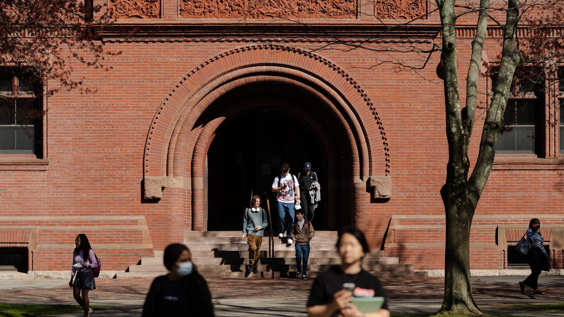 People cross the Harvard Yard at Harvard University on April 17, 2025 in Cambridge.