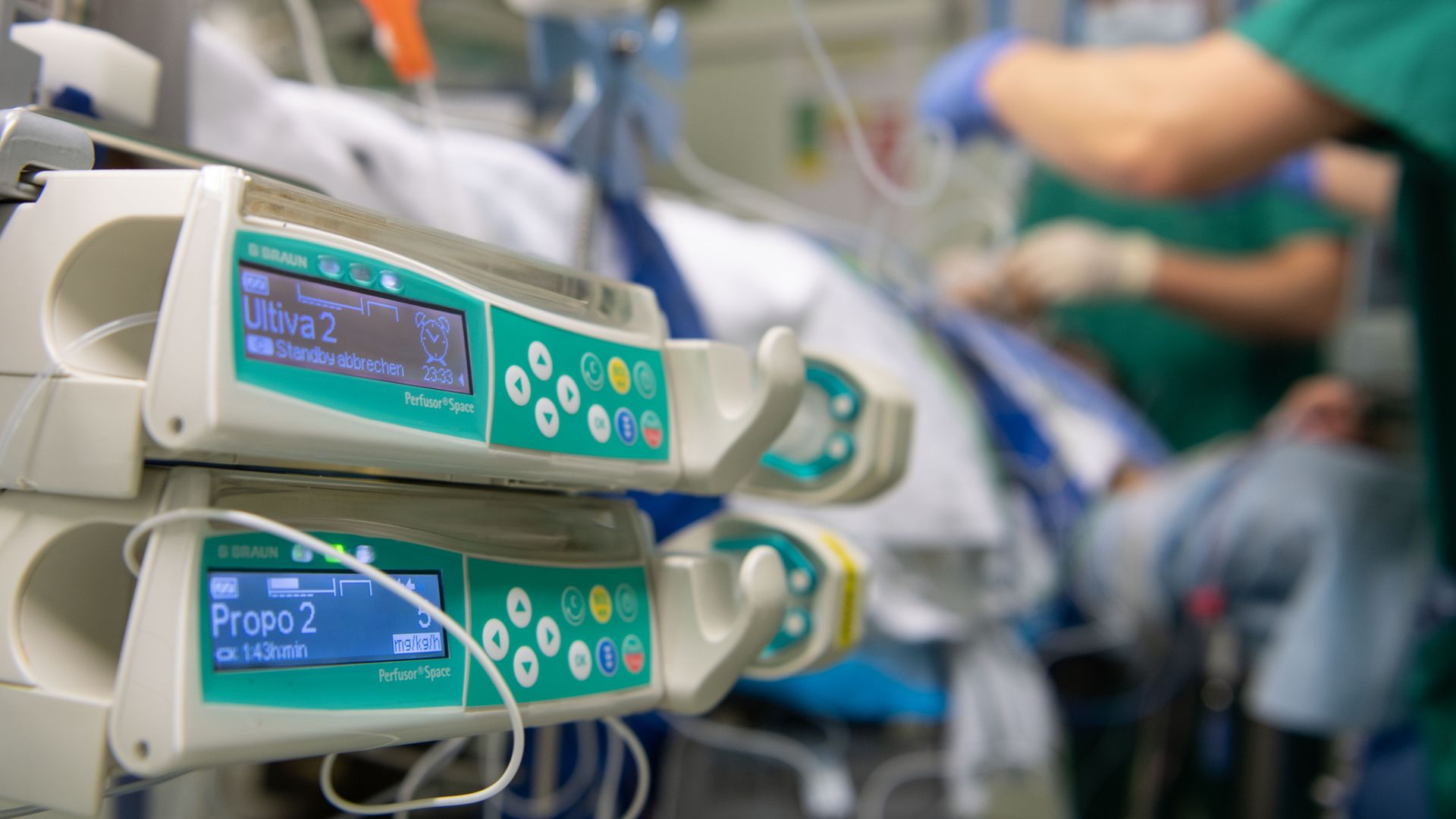 Anesthesiologists prepare a patient with machines surrounding a hospital bed.