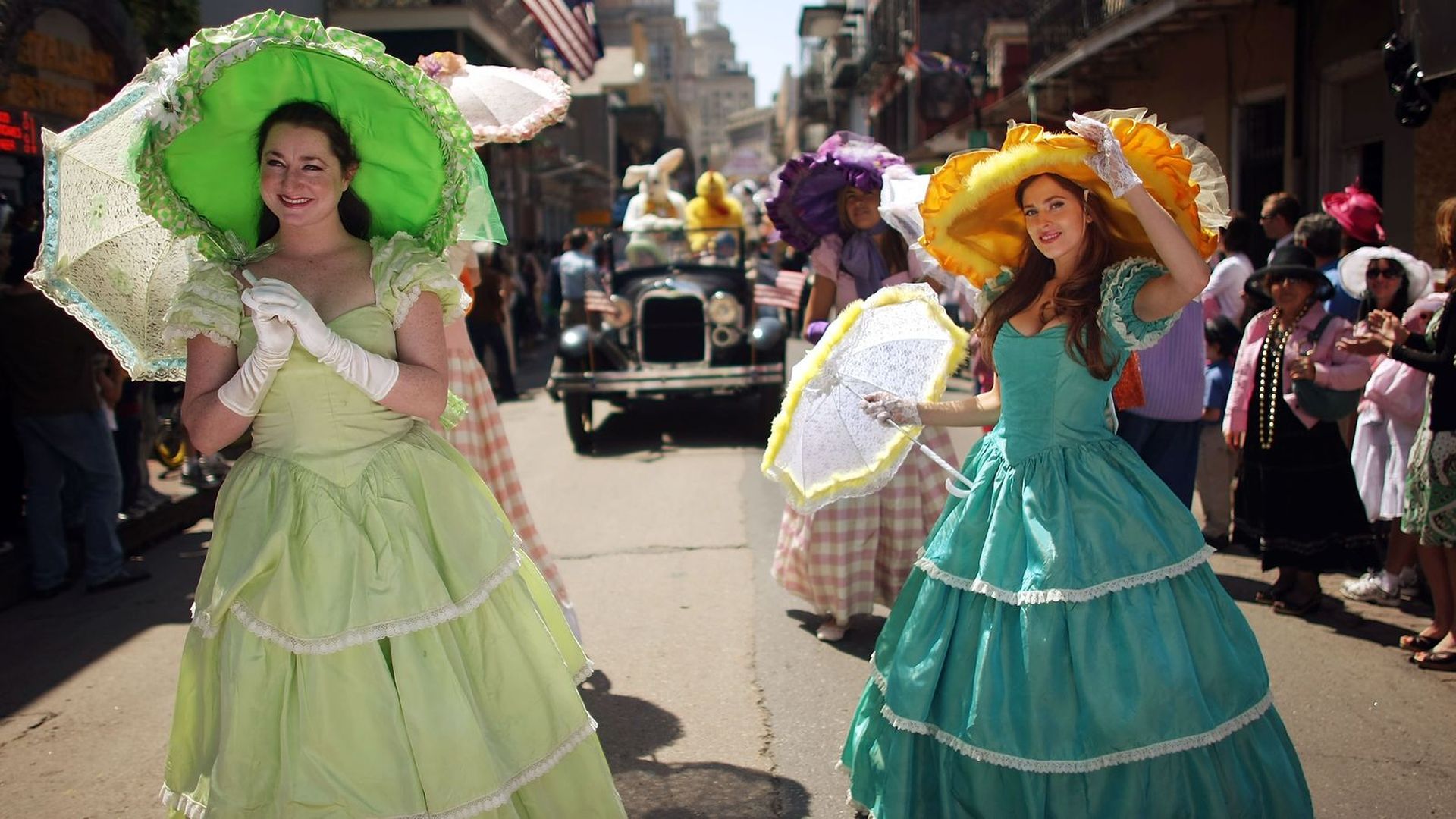 Women dressed in antebellum gowns hold parasols as they march in an Easter parade in the French Quarter.