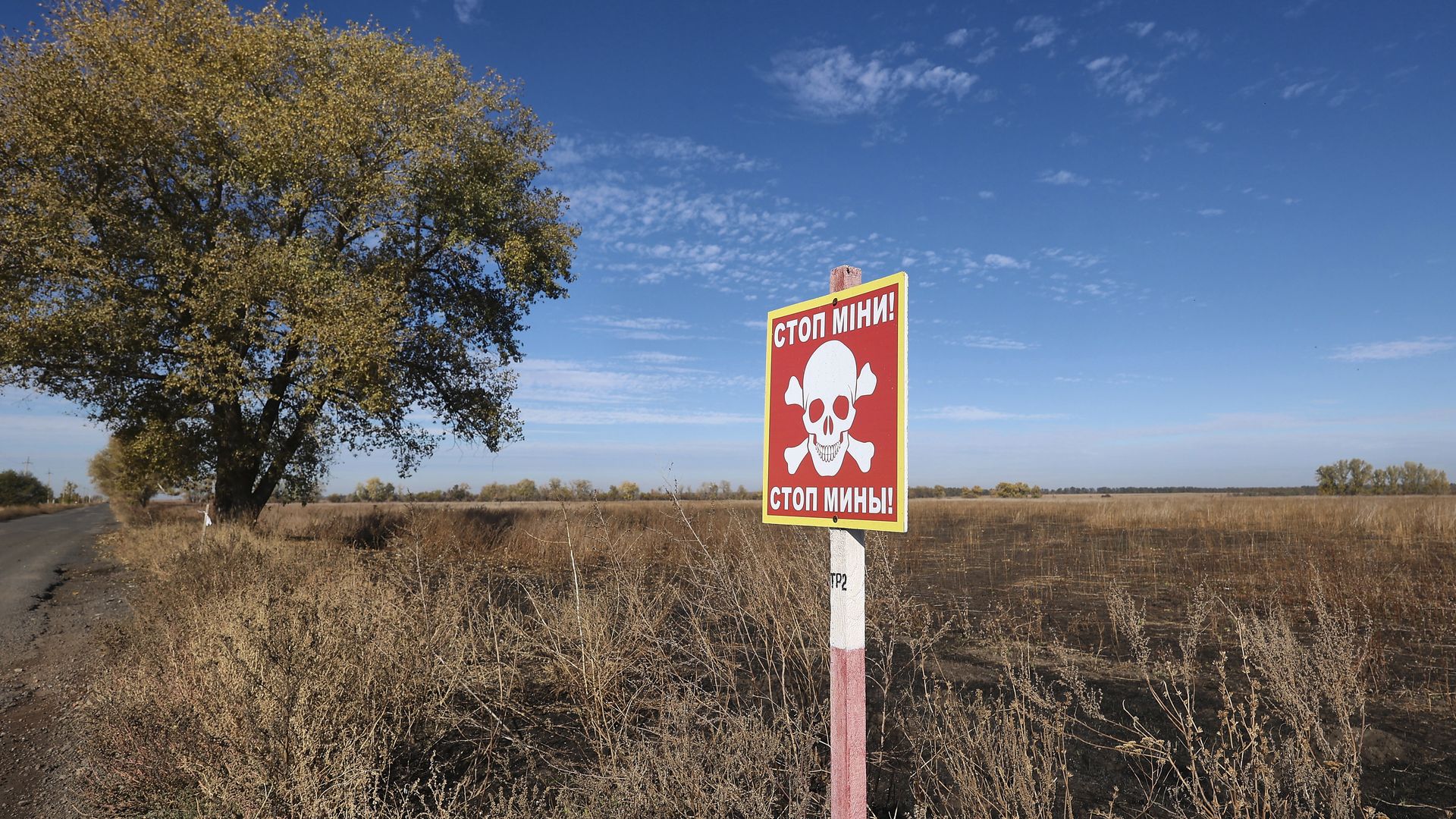 The warning sign "Stop! Mines" is seen in the area where demining was carried out using the latest remote control and soil survey equipment, Kharkiv region, eastern Ukraine