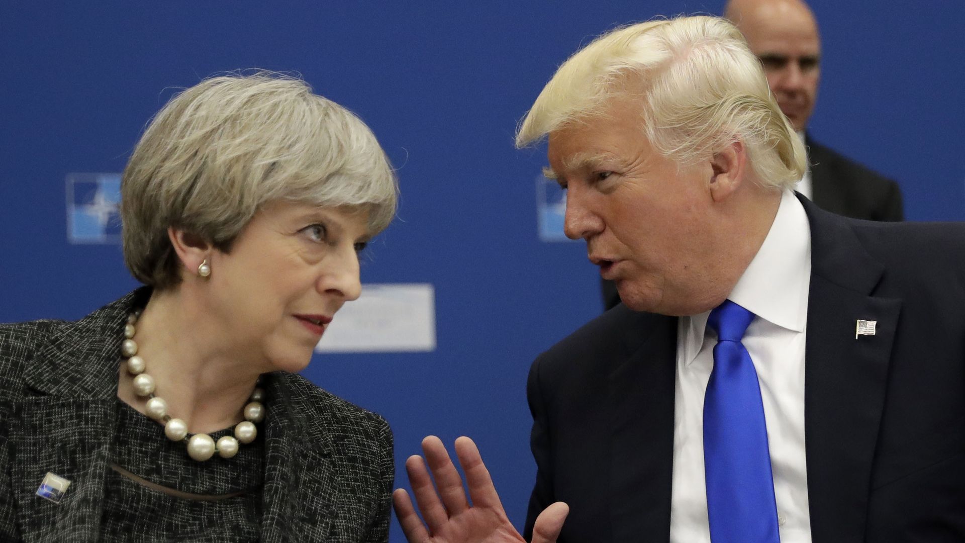  Trump leans over to speak to Theresa May during in a working dinner meeting at NATO HQ 