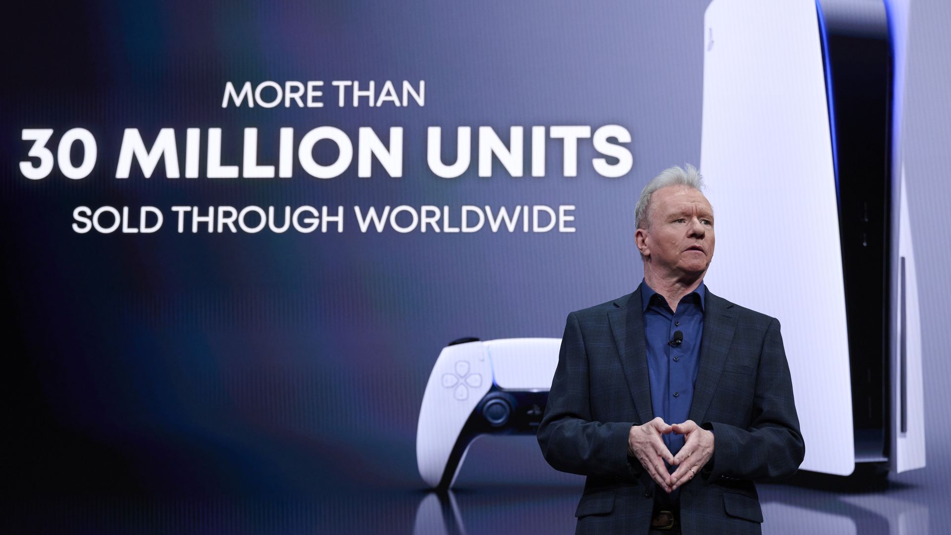 Photo of Jim Ryan in a suit in front of an image of a PlayStation 5 and the words "more than 30 million units sold through worldwide"