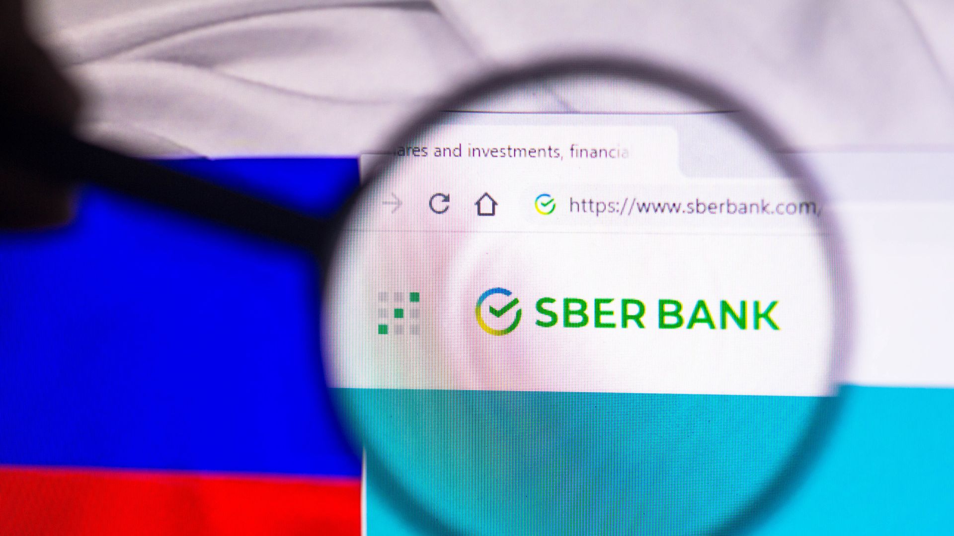 The homepage of Russian bank Sberbank is seen in front of the Russian flag.