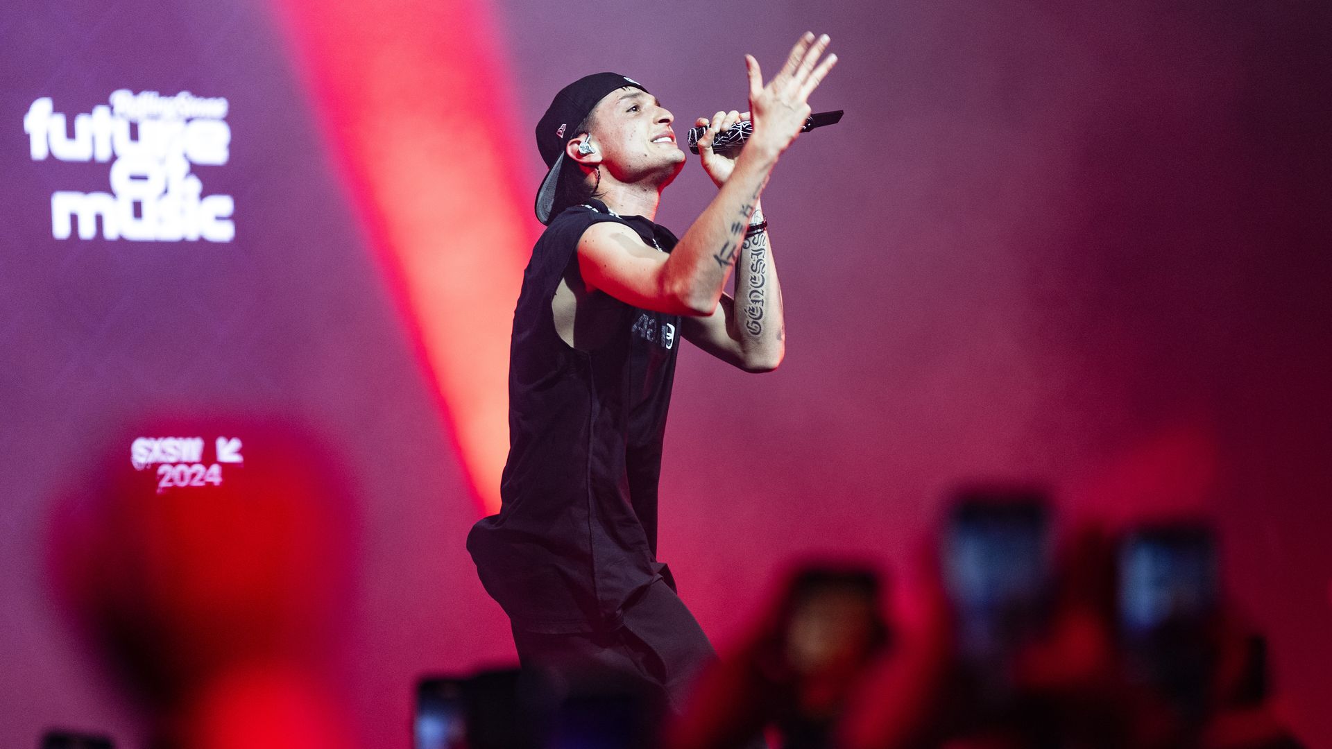A photo of a singer holding a microphone with "Future of Music" written in the background.
