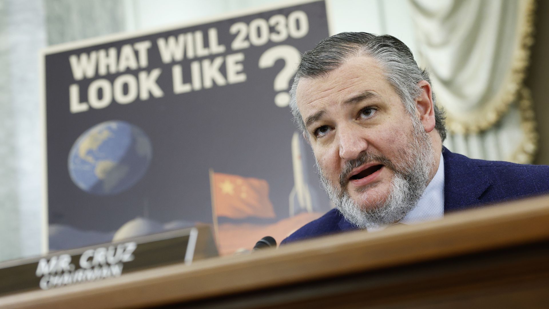 Photo of a man on a podium with a placard behind him that says "What will 2030 look like?" 