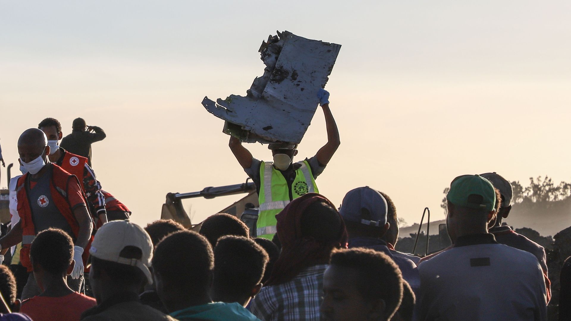  A man carries a piece of debris on his head at the crash site of a Nairobi-bound Ethiopian Airlines flight near Bishoftu