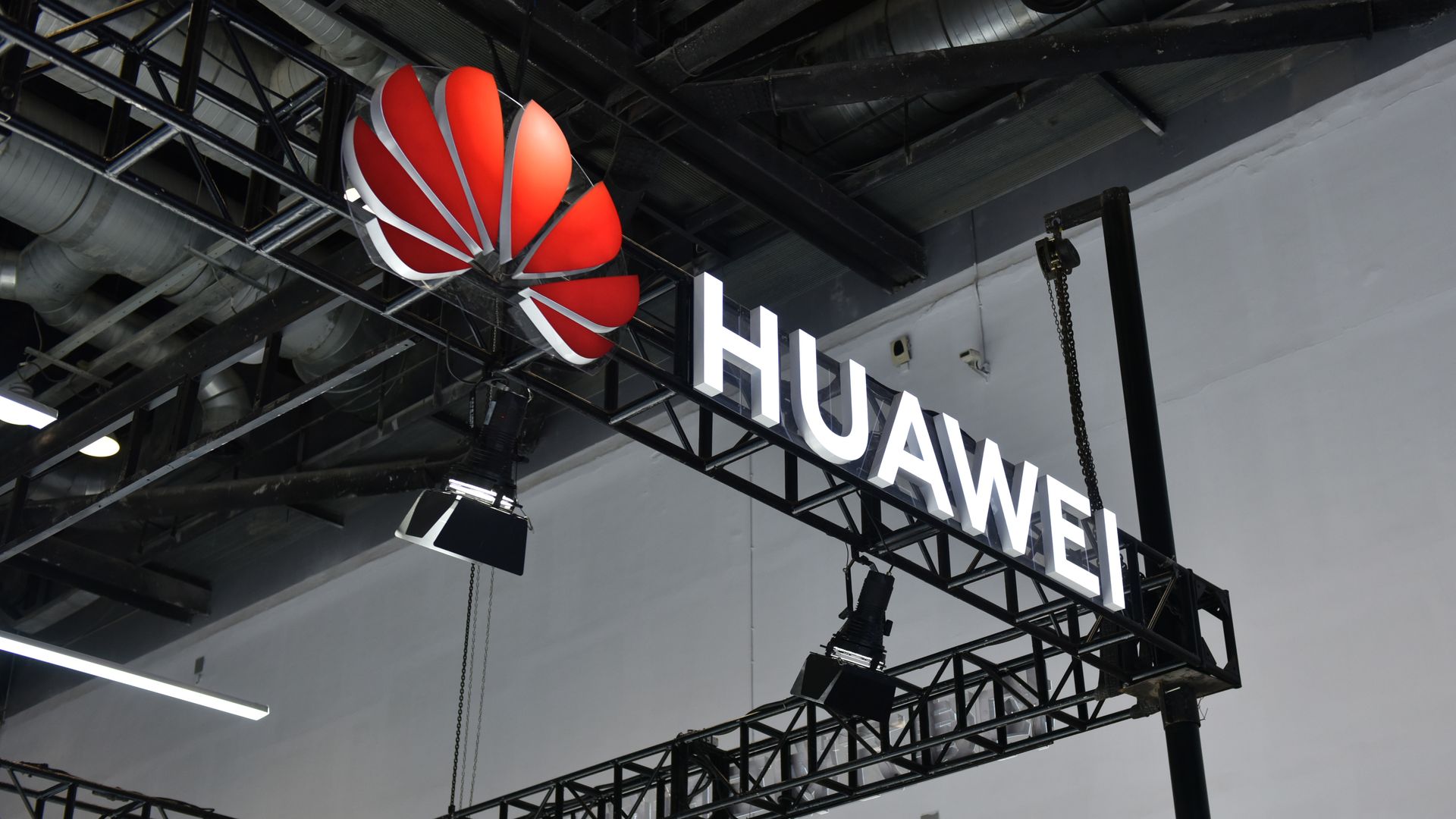 Photo of the Huawei logo hung up as a sign overlooking an exhibition room