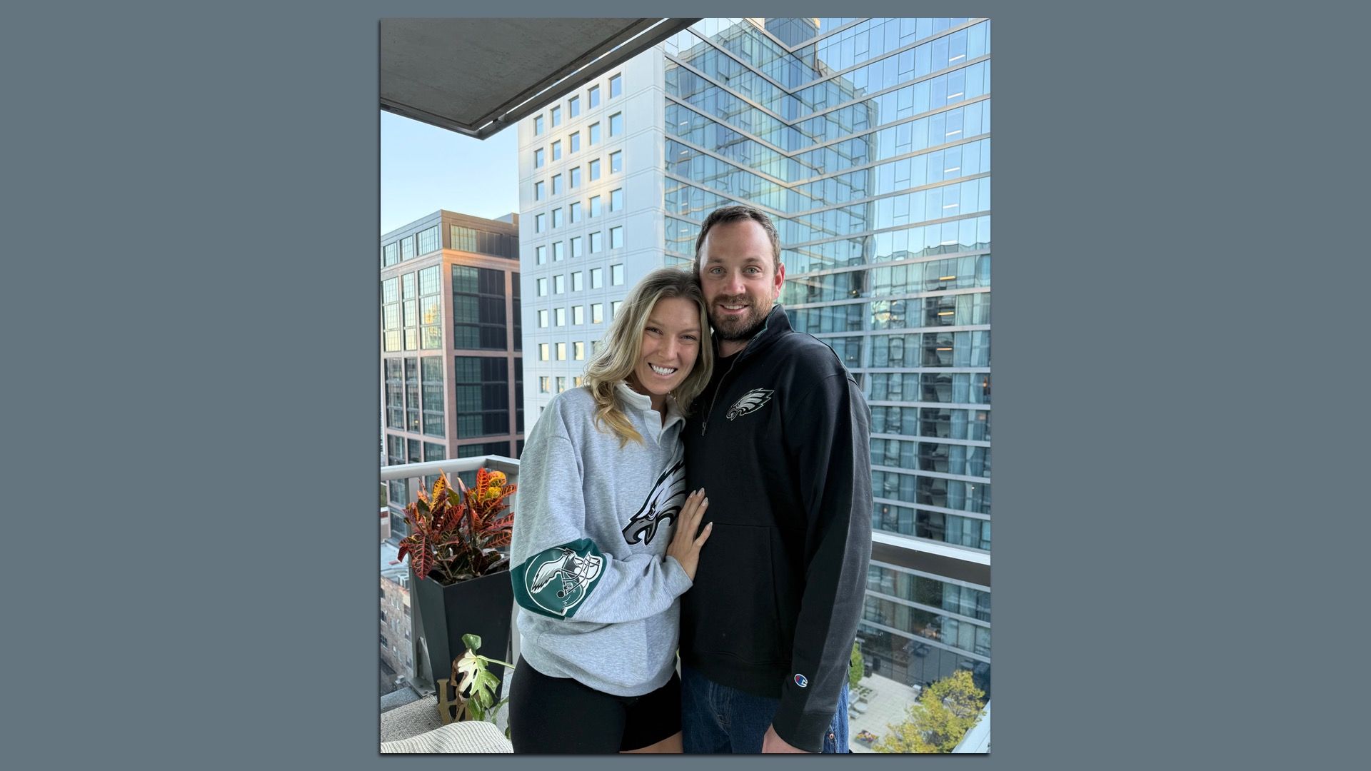Left to right: Lindsey Carl and Brandon Byrd, in Eagles gear, embracing on their balcony.