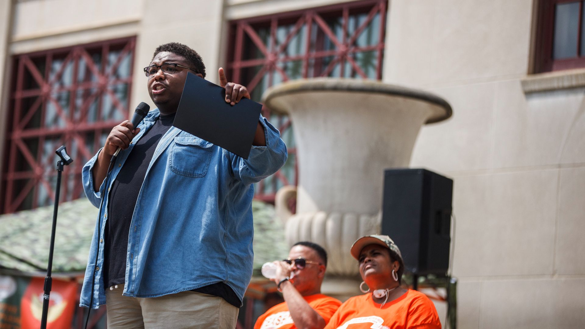 State lawmaker Dontavius Jarrells speaks at an anti-violence rally at Columbus City Hall with two activists pictured behind him.