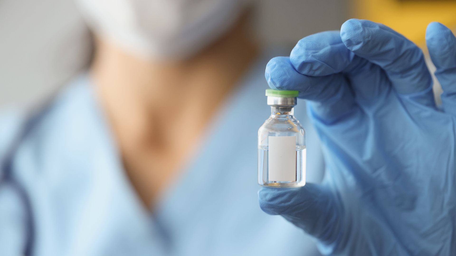 Medical profession holding a vial.