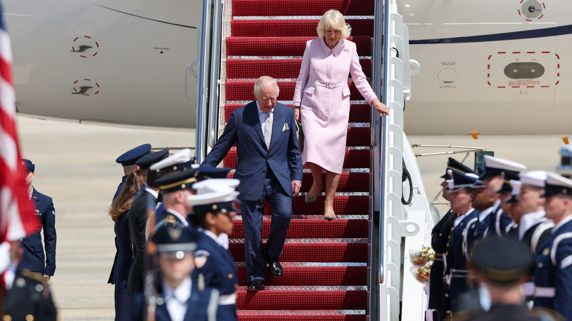 King Charles III and Queen Camila walking down the stairs from the airplane at Joint Base Andrews in Maryland.