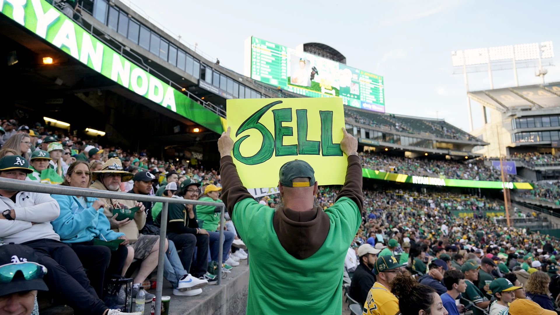 fan holds "sell" sign