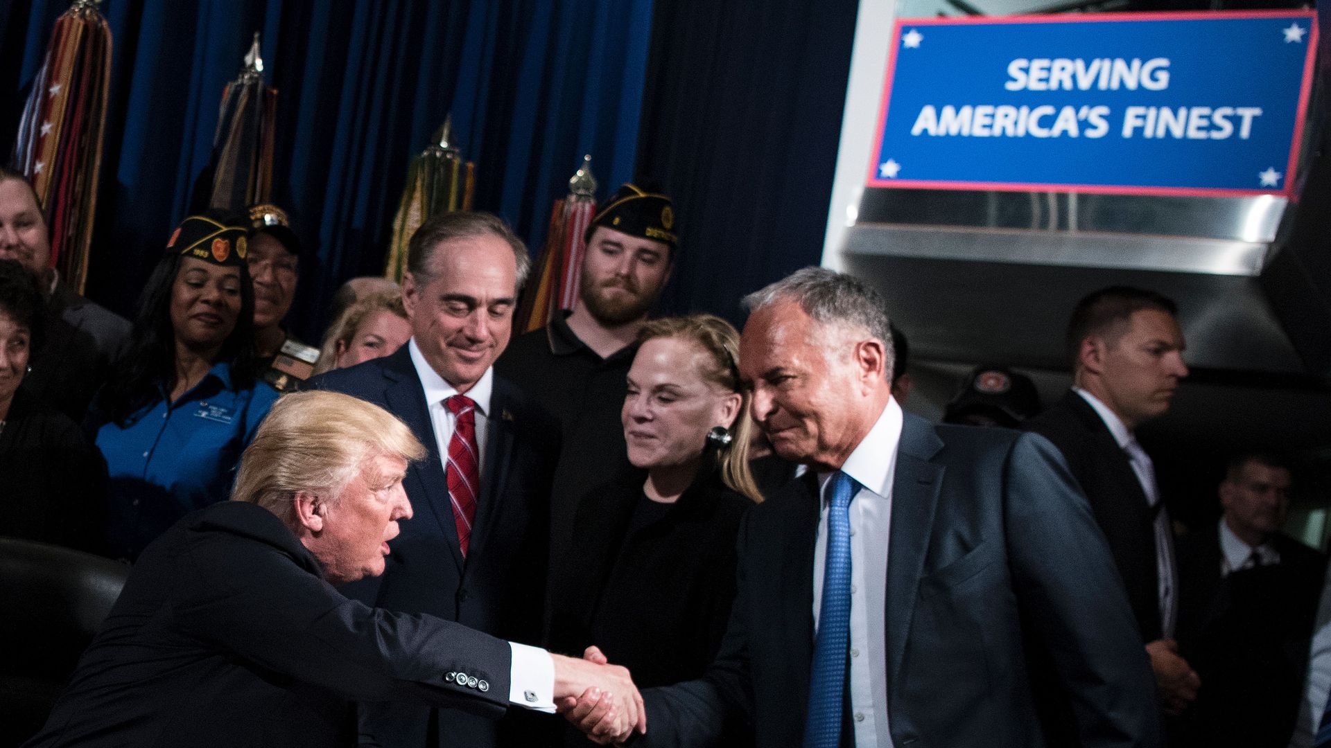 Trump shaking hands with Ike Perlmutter with David Shulkin looking on