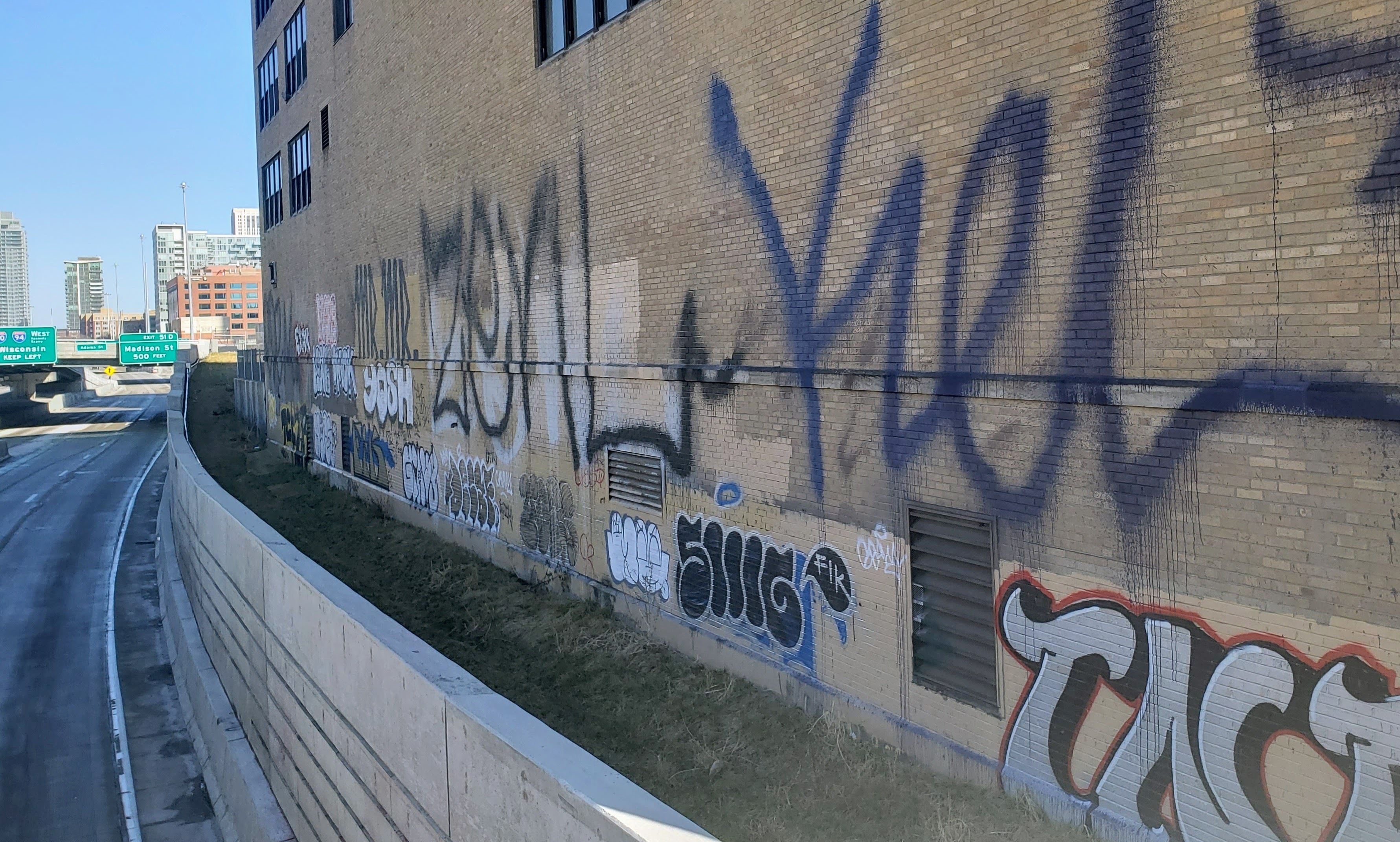Photo of graffiti on wall next to highway