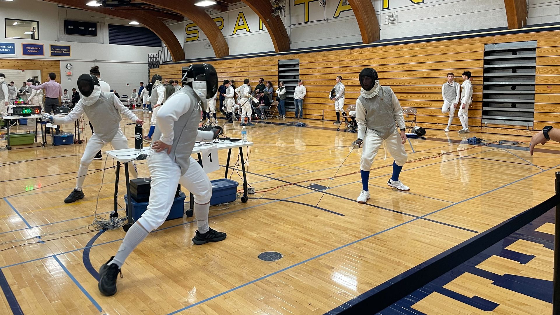 People fencing in a gym