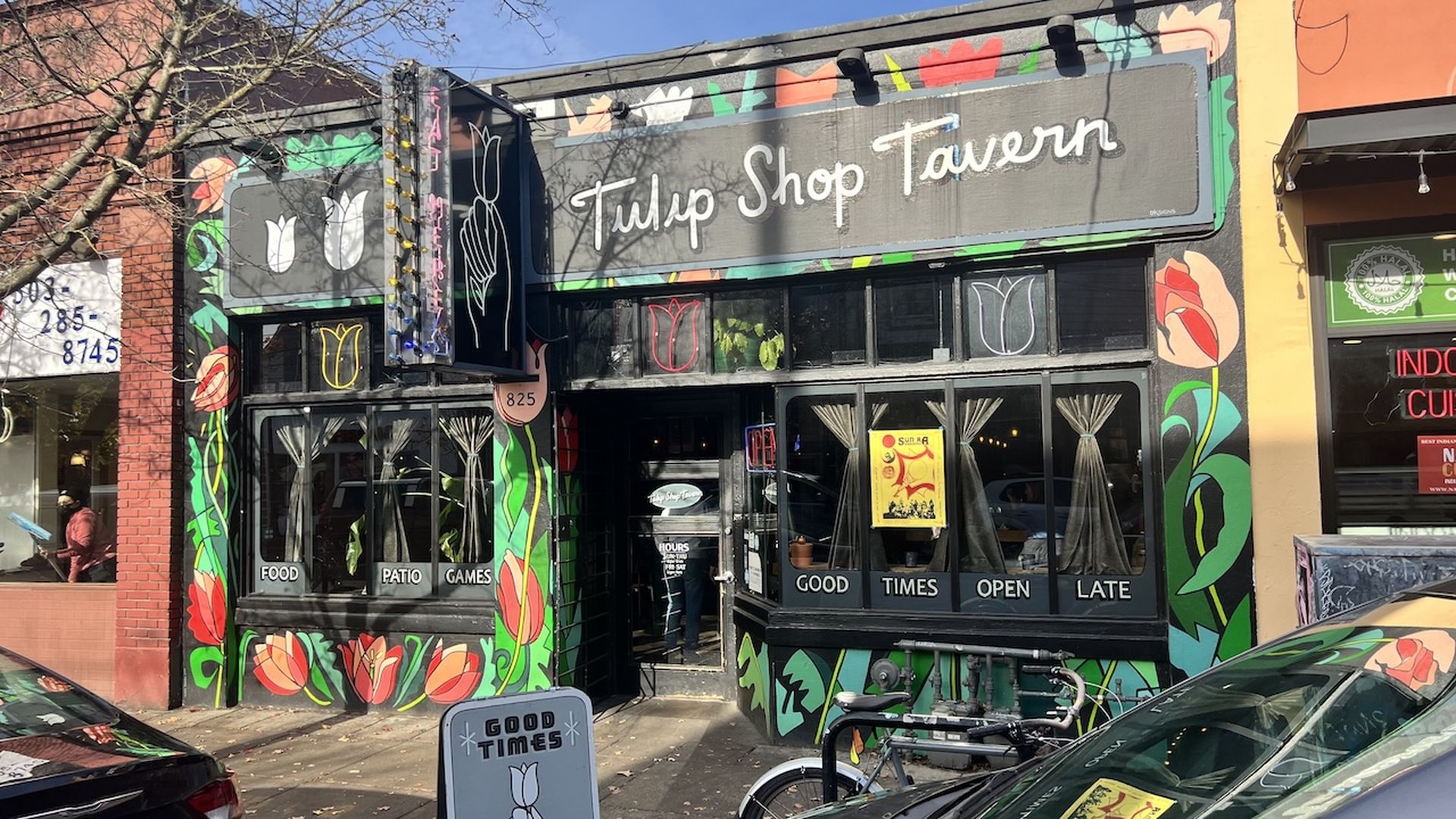 A photo of a storefront that is painted to show tulips growing from the bottom up to the roof.