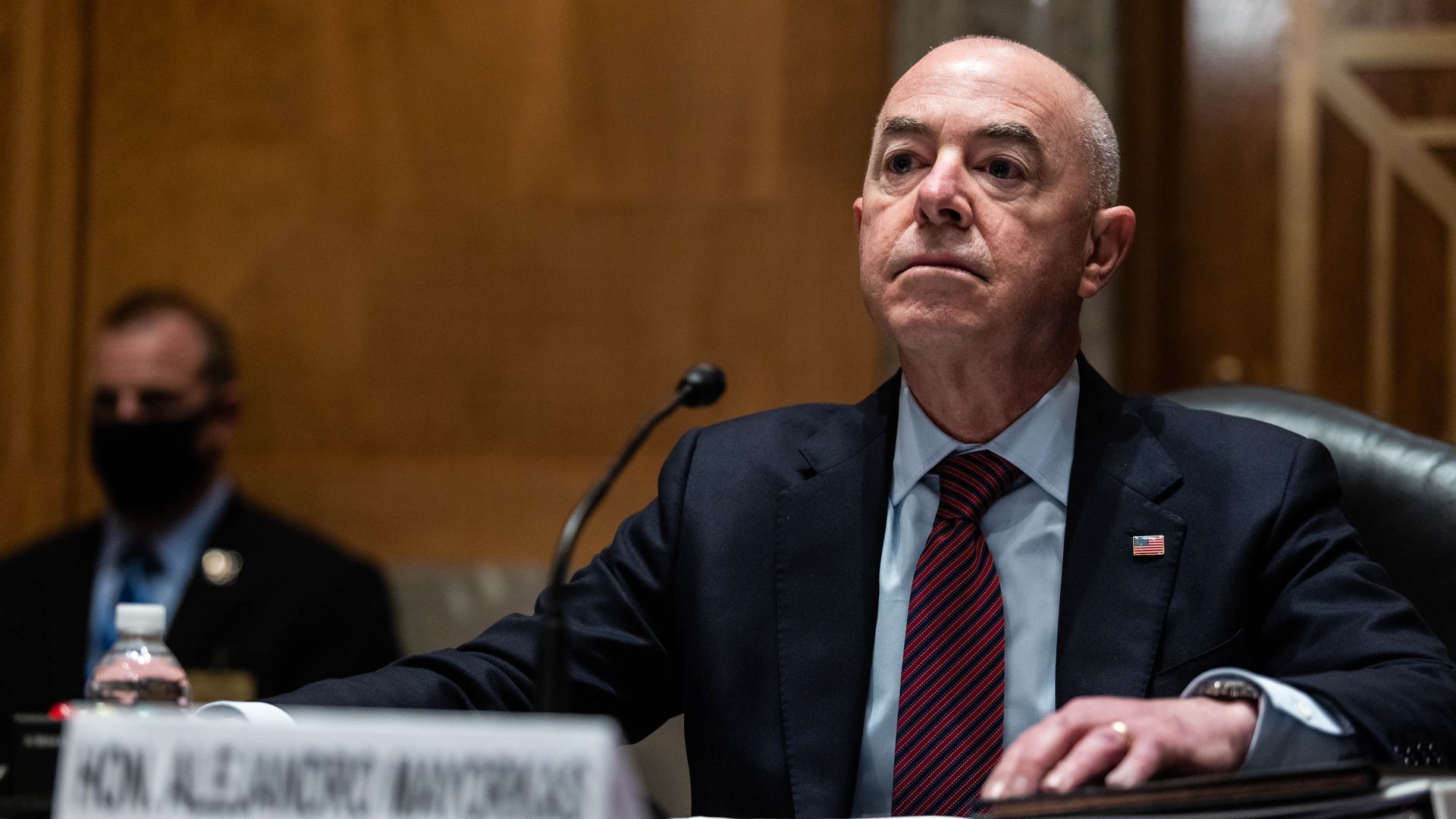 Photo of Alejandro Mayorkas sitting in front of a mic