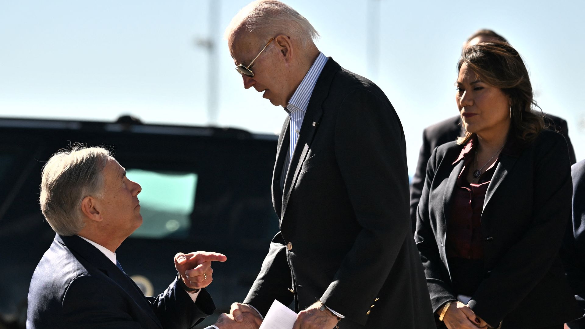 President Biden shaking hands with Texas Gov. Greg Abbott after departing an airplane in El Paso on Jan. 8.
