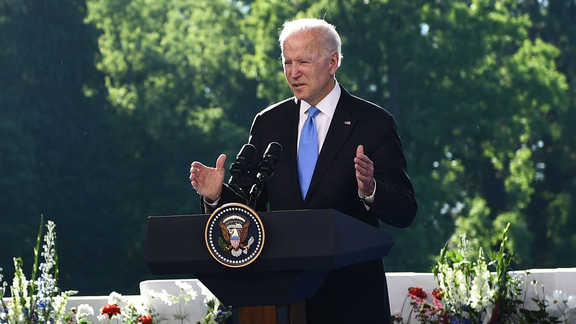 Biden stands behind a podium while speaking