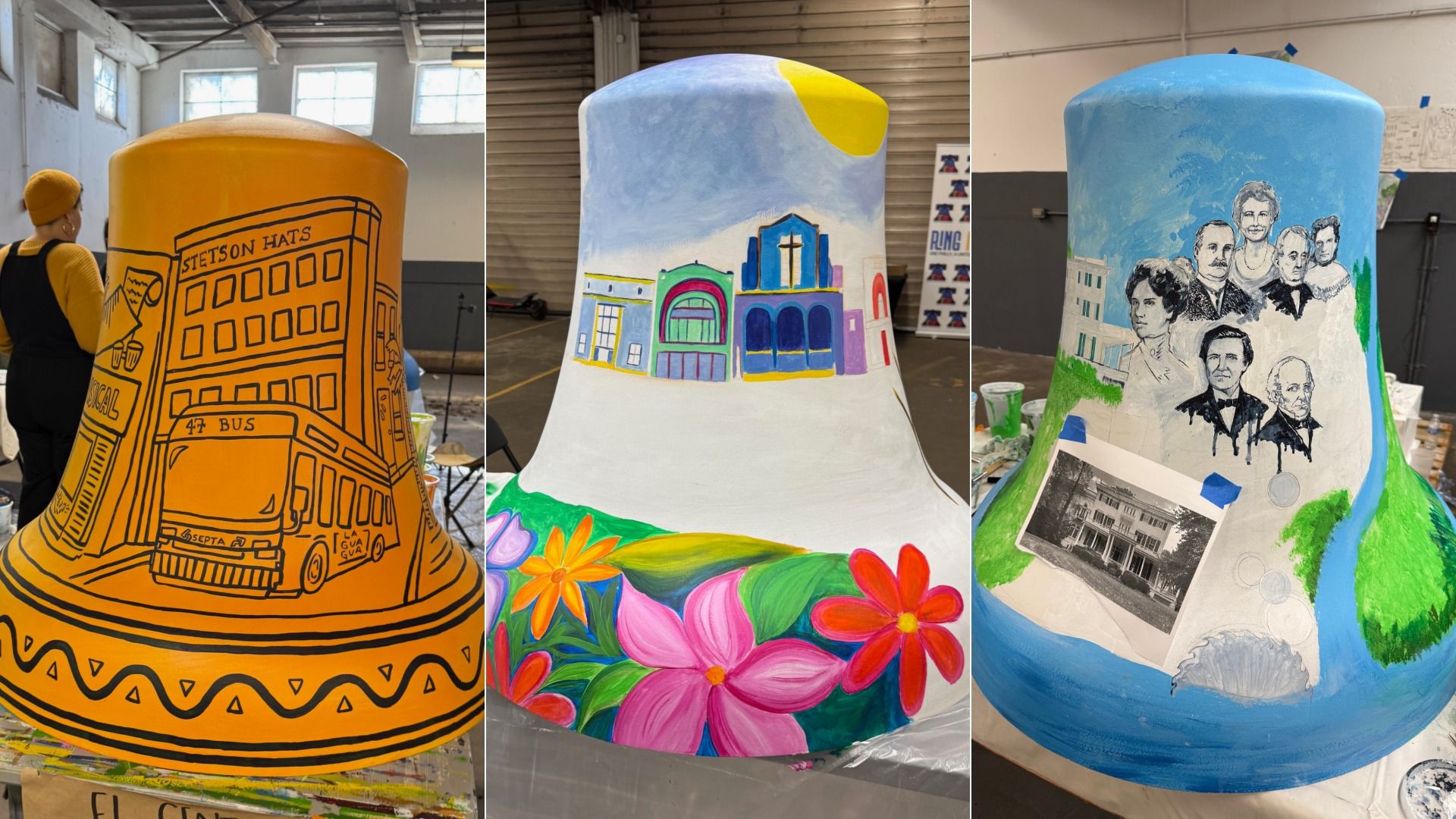 Three large bell-shaped sculptures painted differently: one orange with black outlines of buildings and a bus; one white with colorful flowers, blue church, and yellow sun; one blue with historical portraits and old house photo.