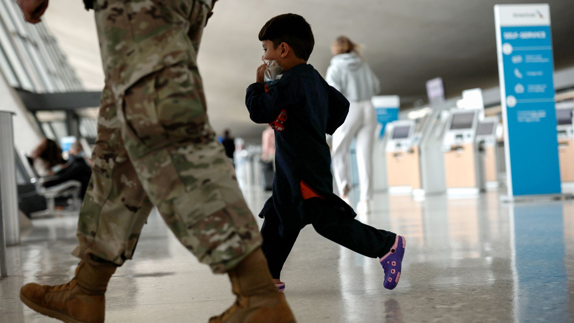 Afghan child with soldier at airport