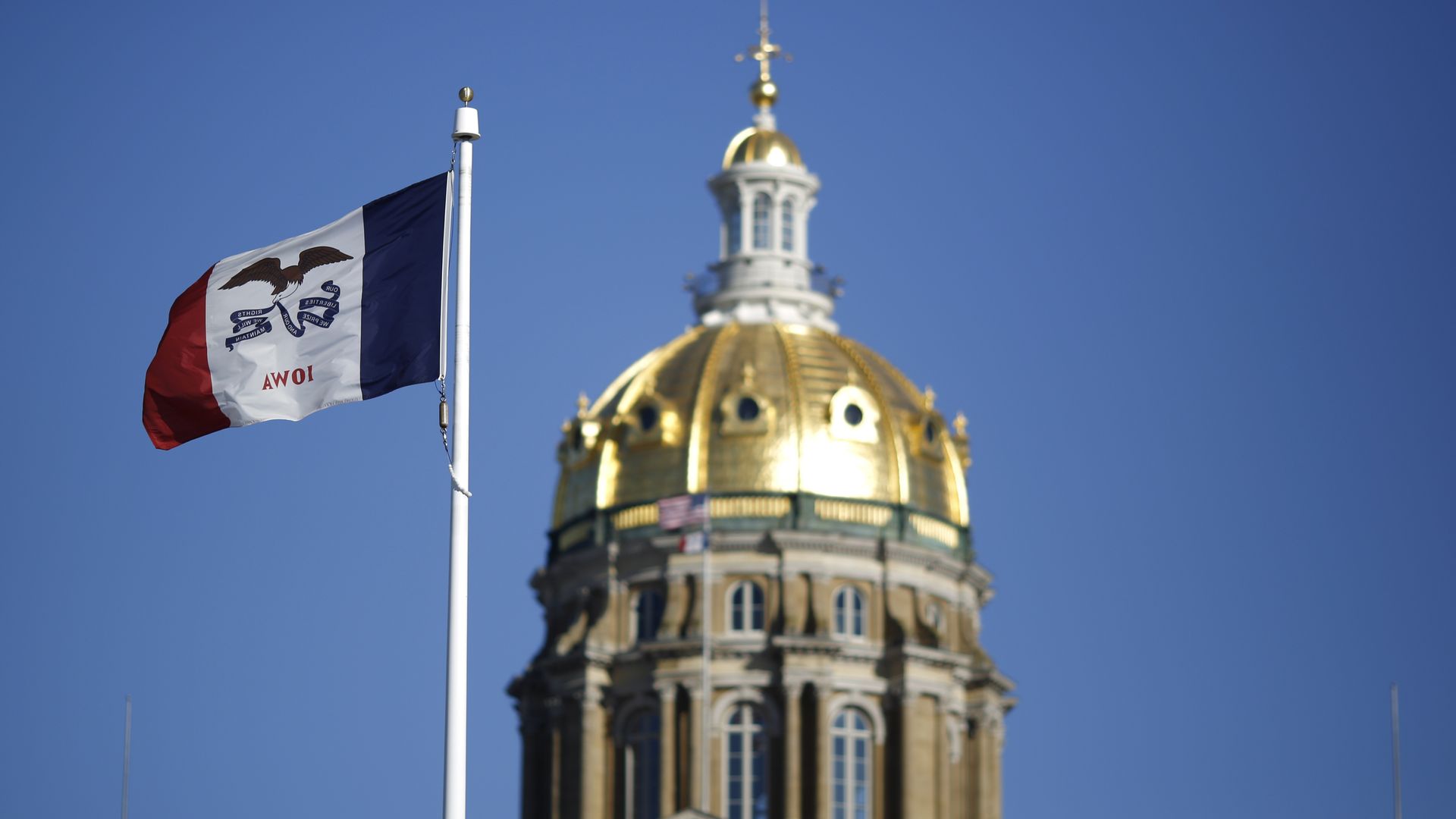 The Iowa state flag flies outside the State Capitol Building in Des Moines, Iowa