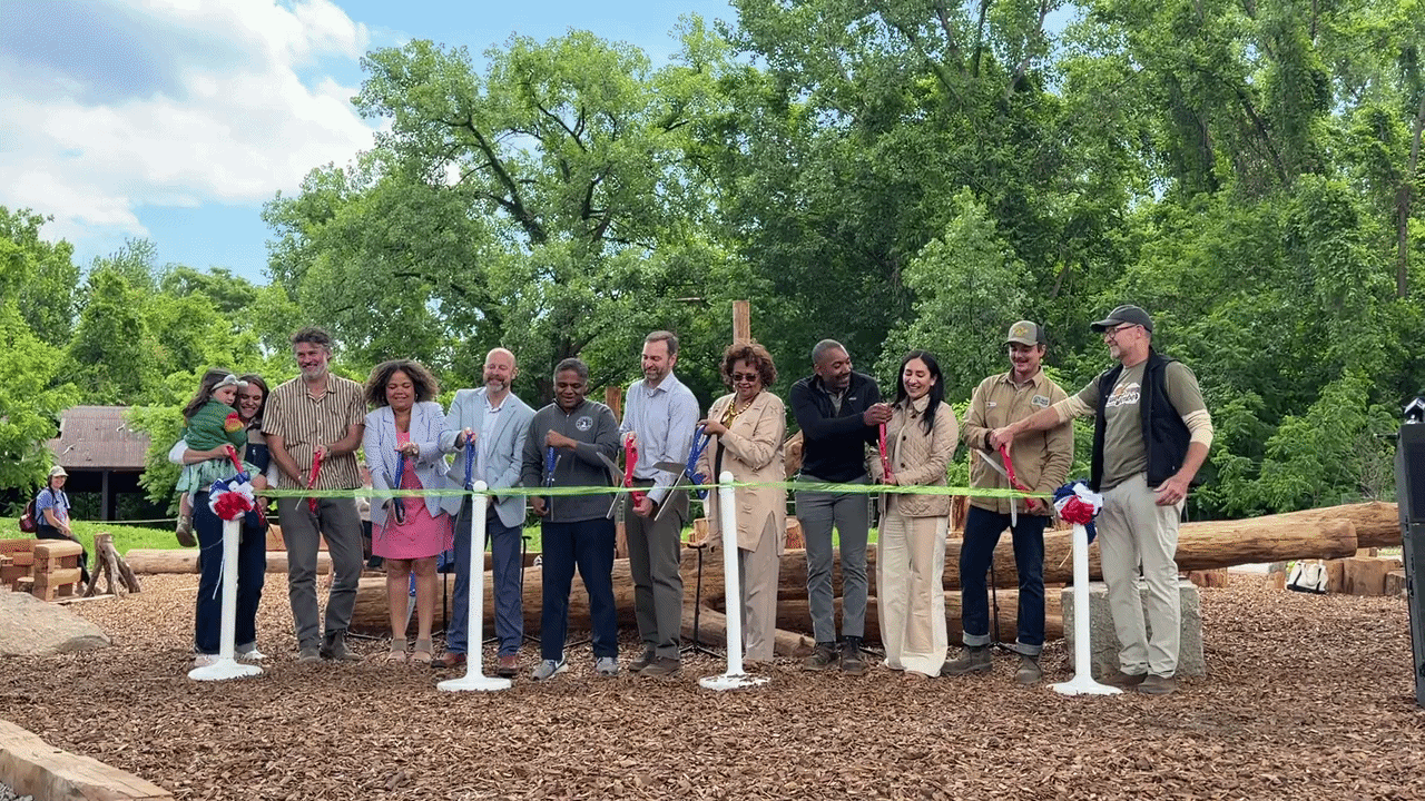 a bunch of people doing a ribbon cutting 