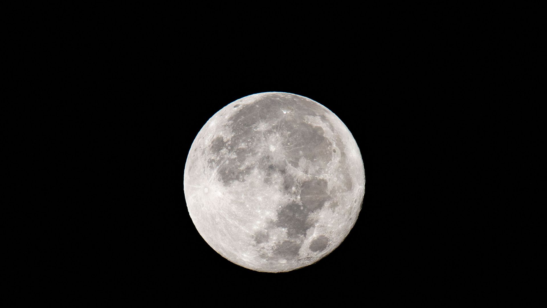 A full supermoon sets behind the Santa Ynez Mountain Range as viewed on August 31, 2023