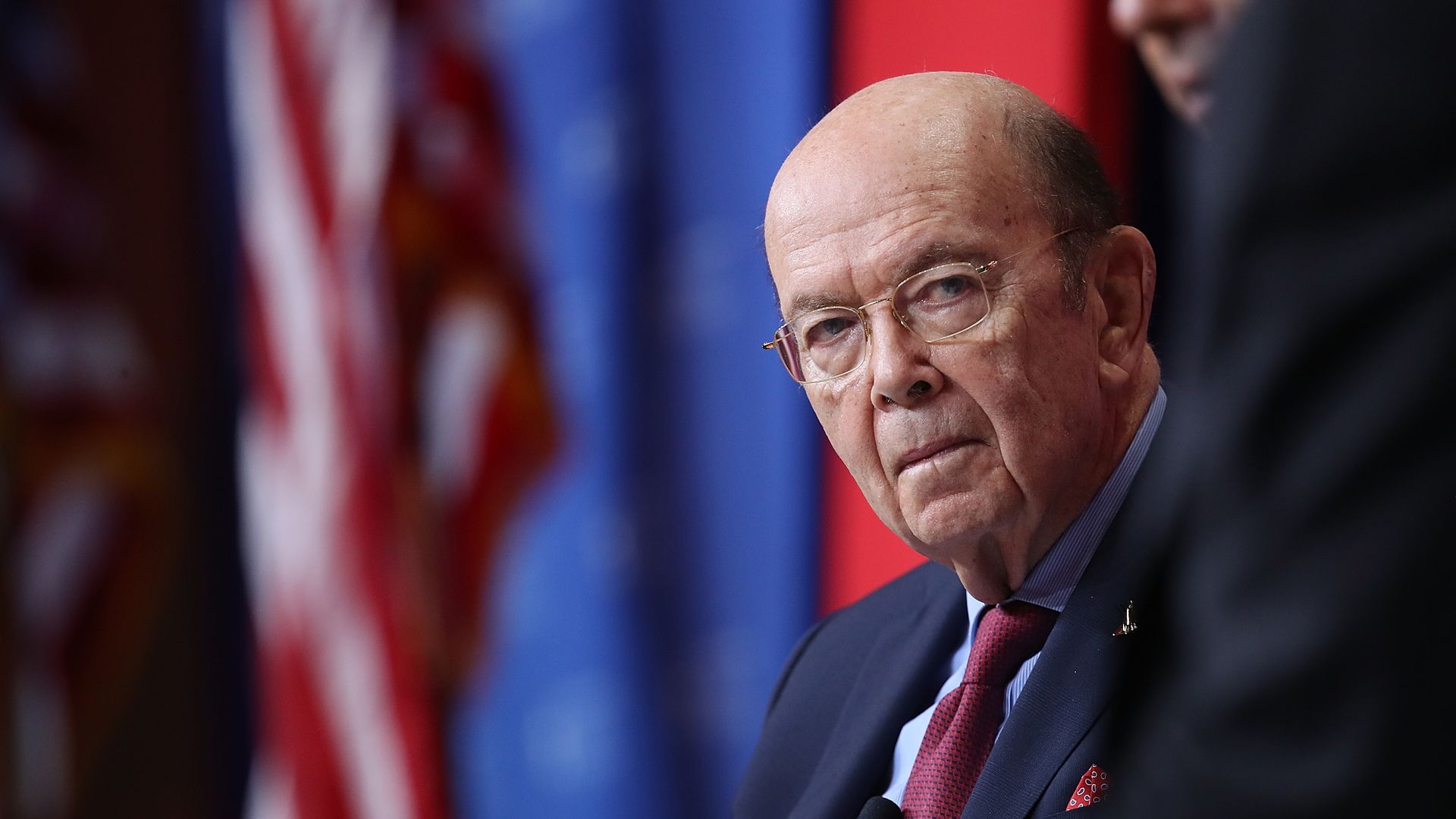 Wilbur Ross in front of an American flag