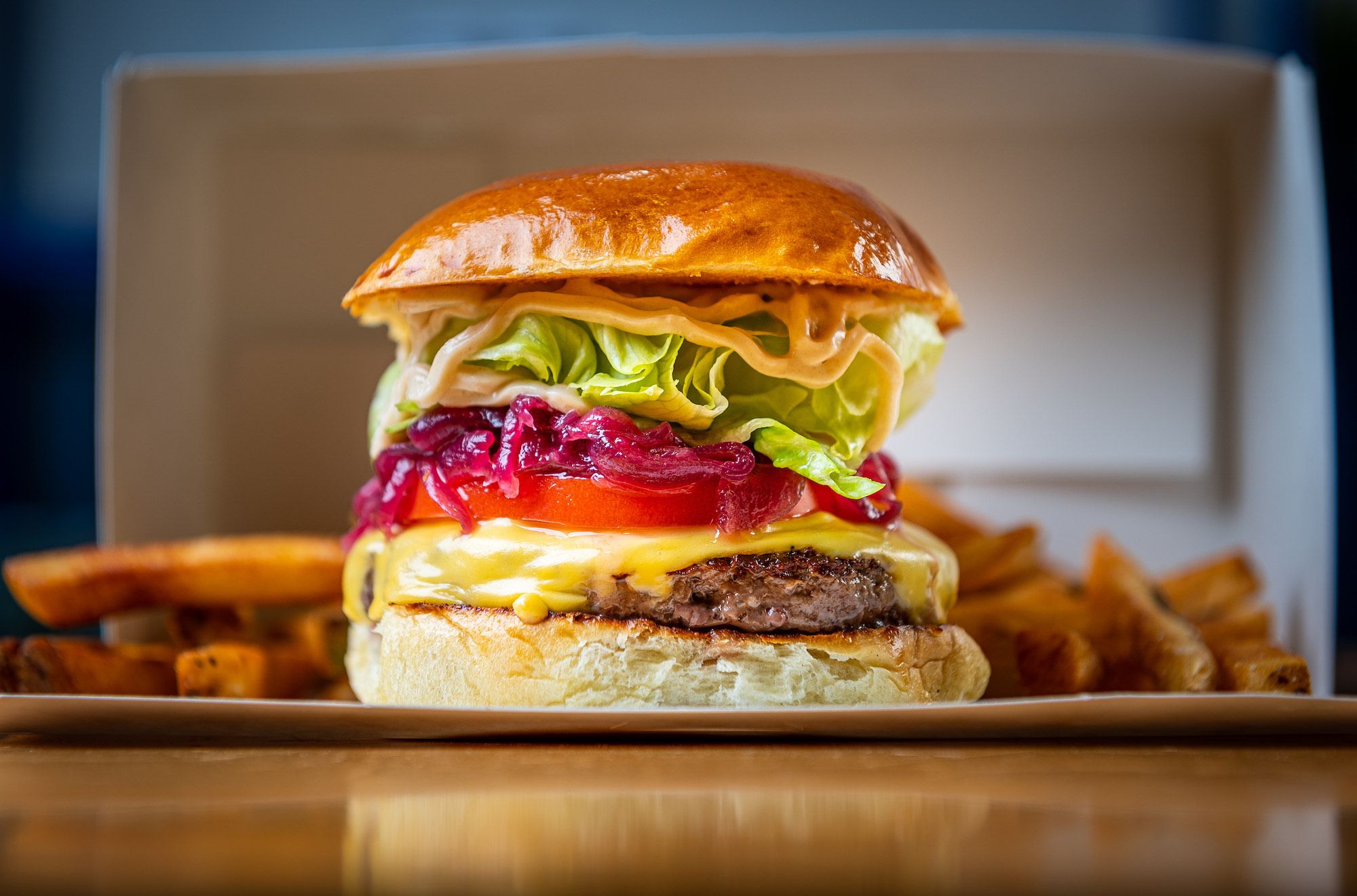 The classic Melange burger piled high with cheese, tomato, pickled onion and lettuce