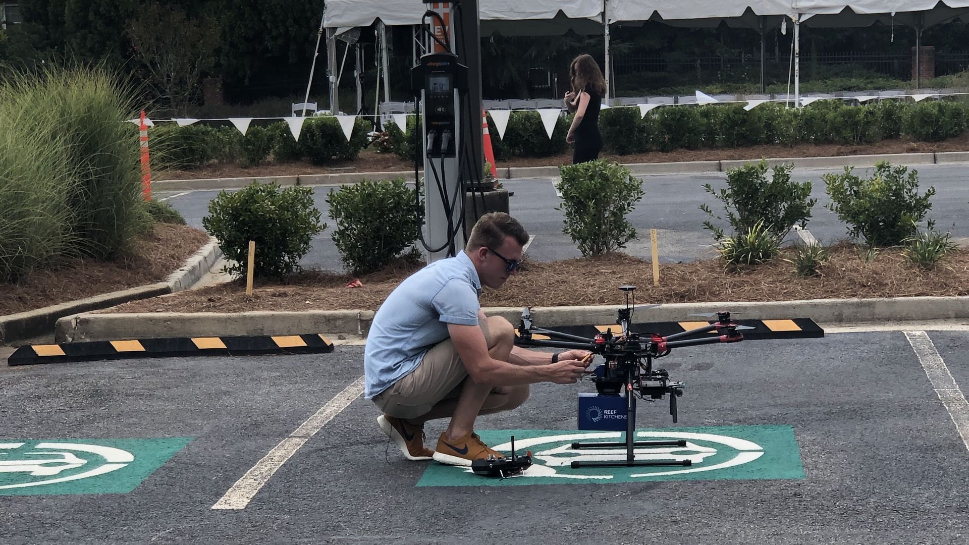 Drone operator adjusts package to be carried under drone