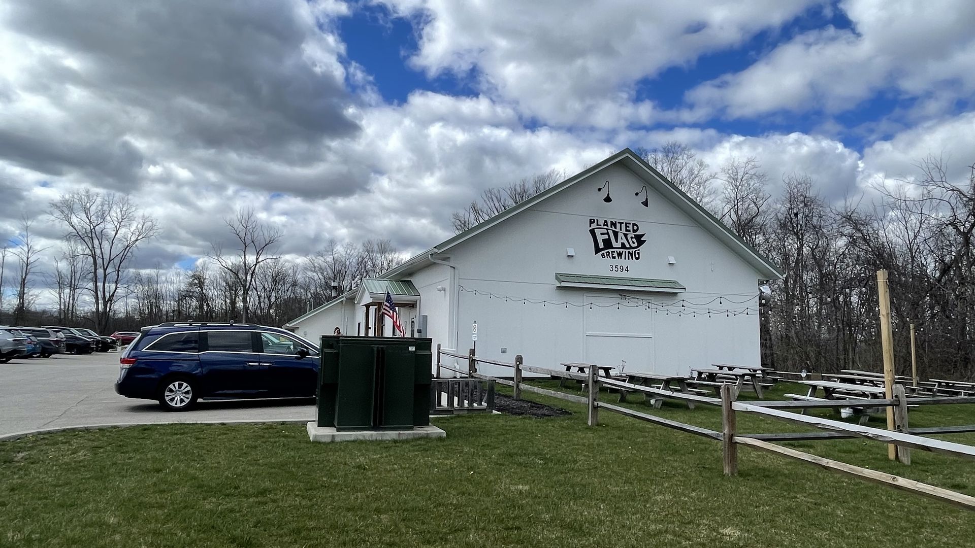 An exterior photo of a barnhouse brewery in exurban Cleveland, Ohio. Blue sky with clouds in background. 