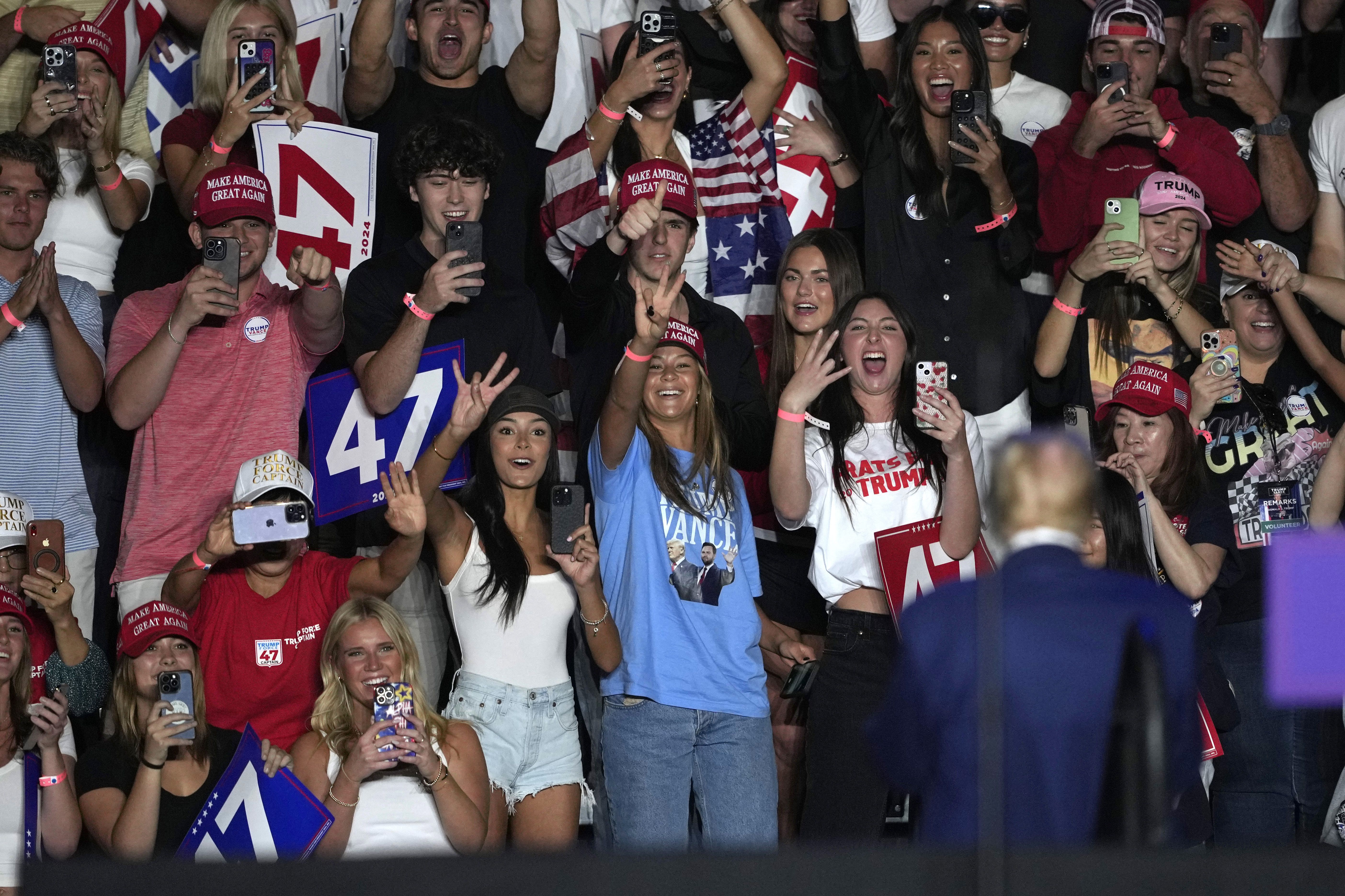 Supporters flashing an Arizona State hand sign wave at former President Trump at a rally yesterday in Tempe, Ariz.