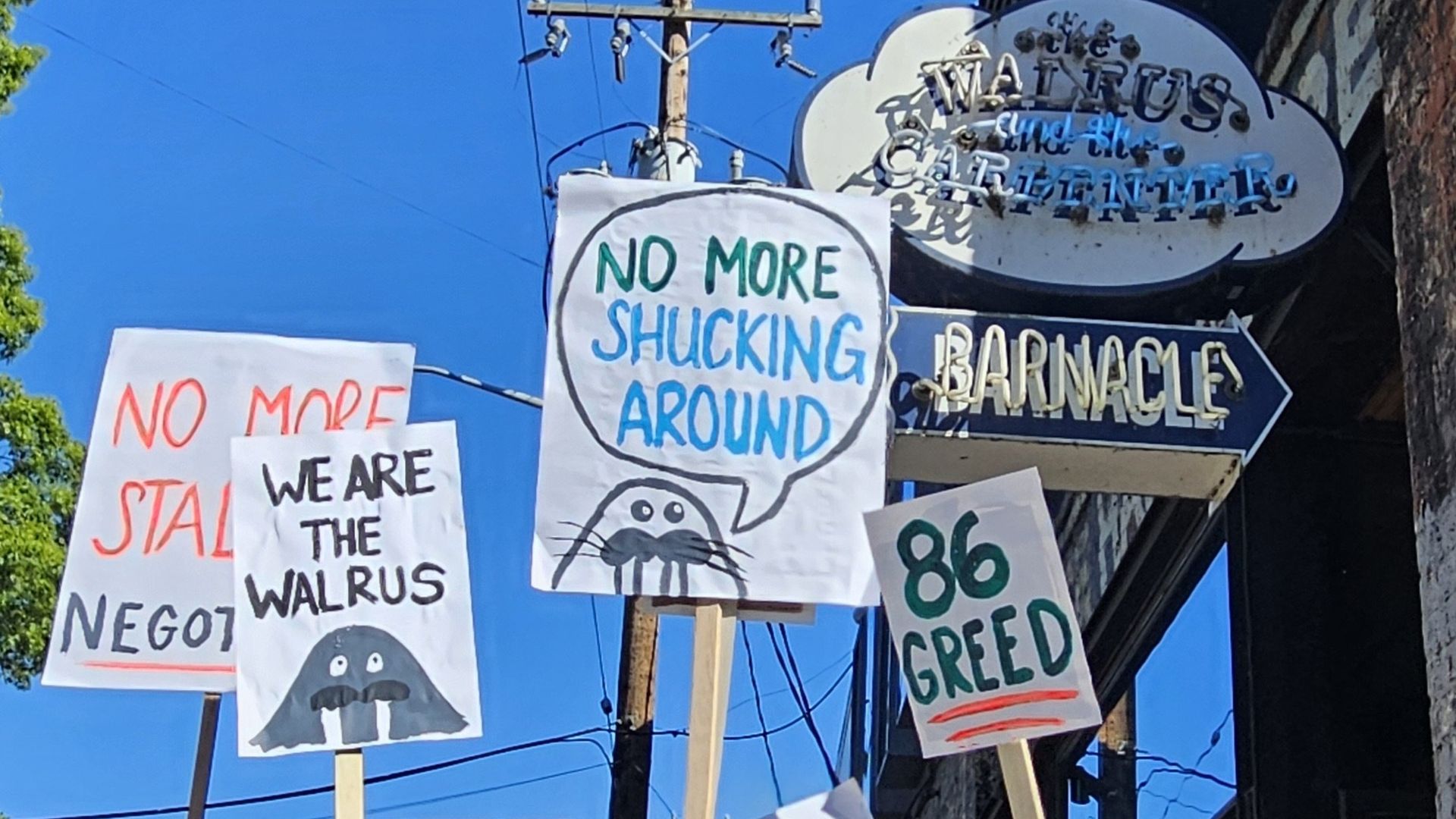 Picket signs are held up outside Seattle's Walrus and the Carpenter restaurant in Ballard.
