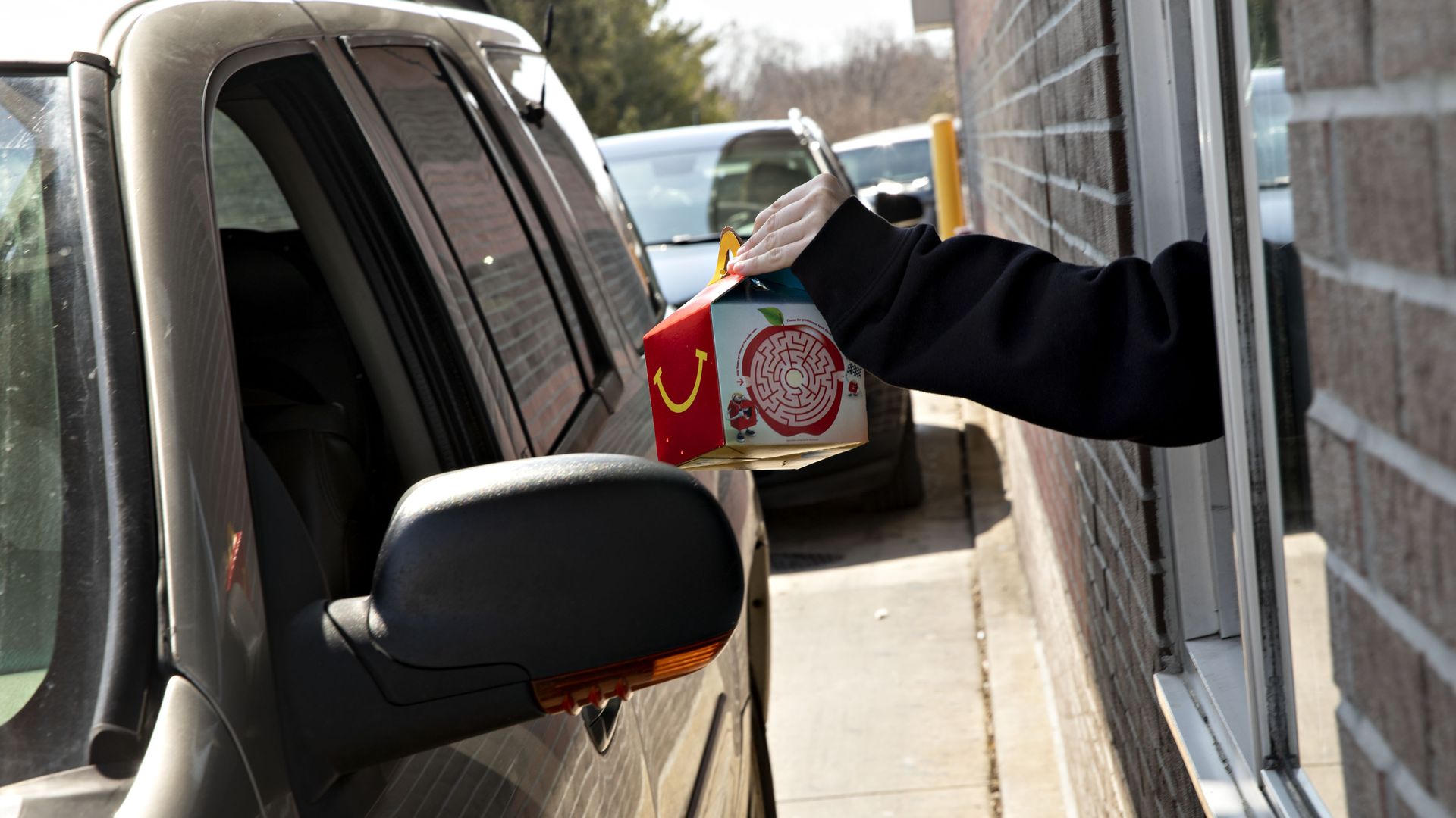 A McDonald's employee handing a customer a Happy Meal through the drive through in Peru, Illinois, in March 2019. 