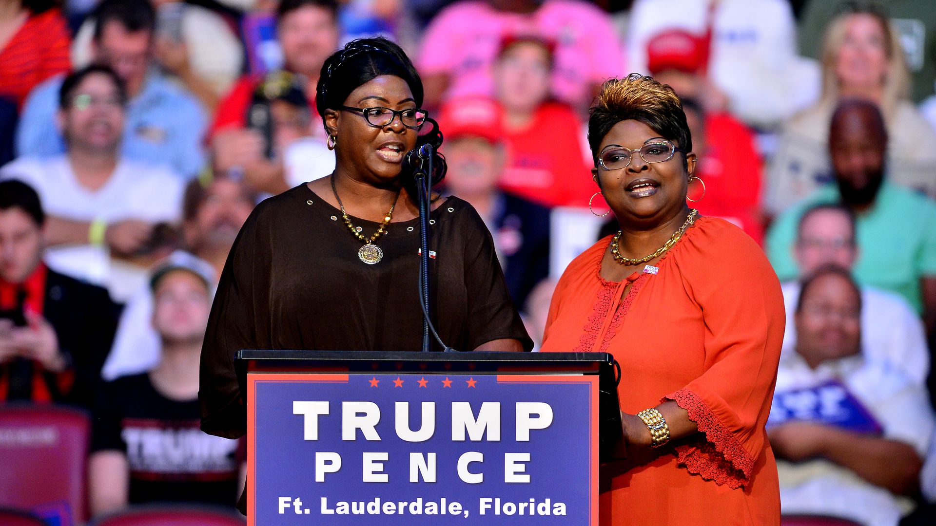 Diamond and Silk speak on stage at a Trump rally