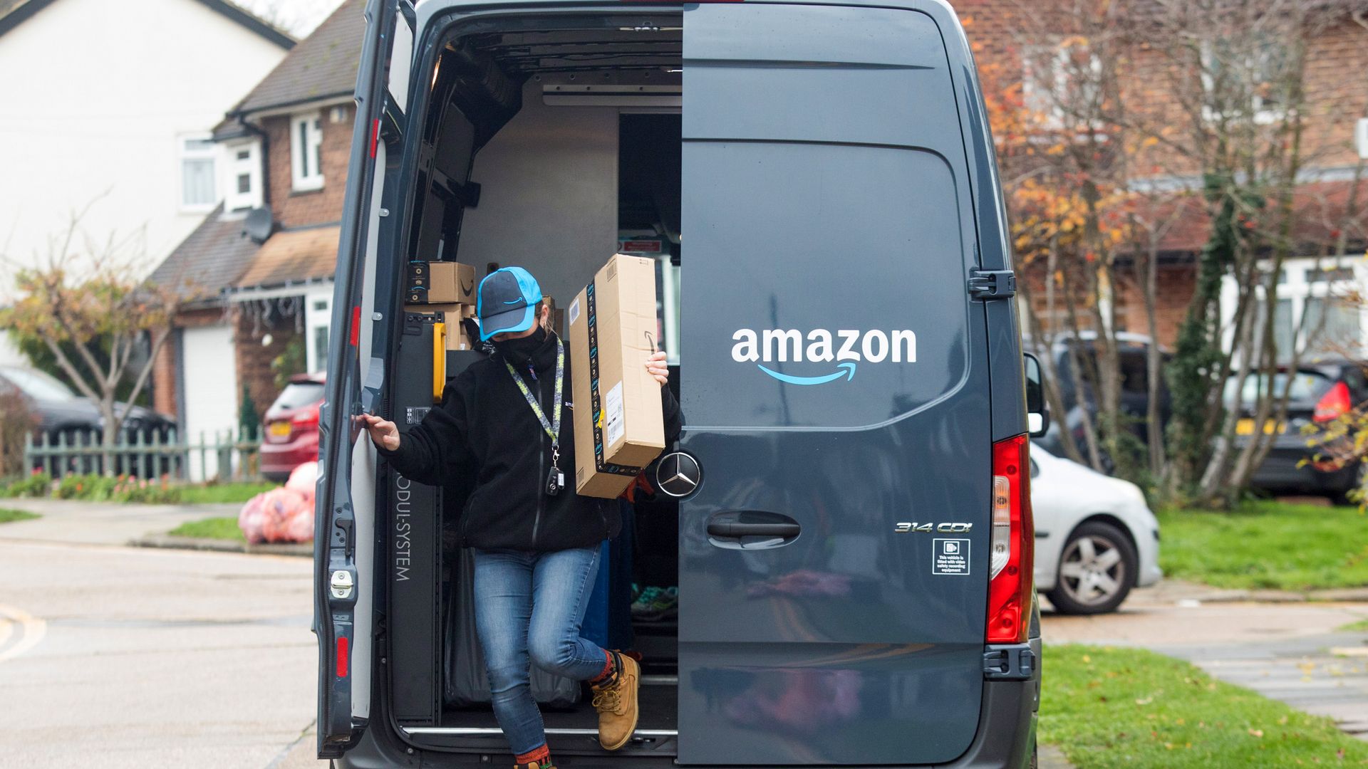 Picture of Amazon employee getting off an Amazon ban carrying a package