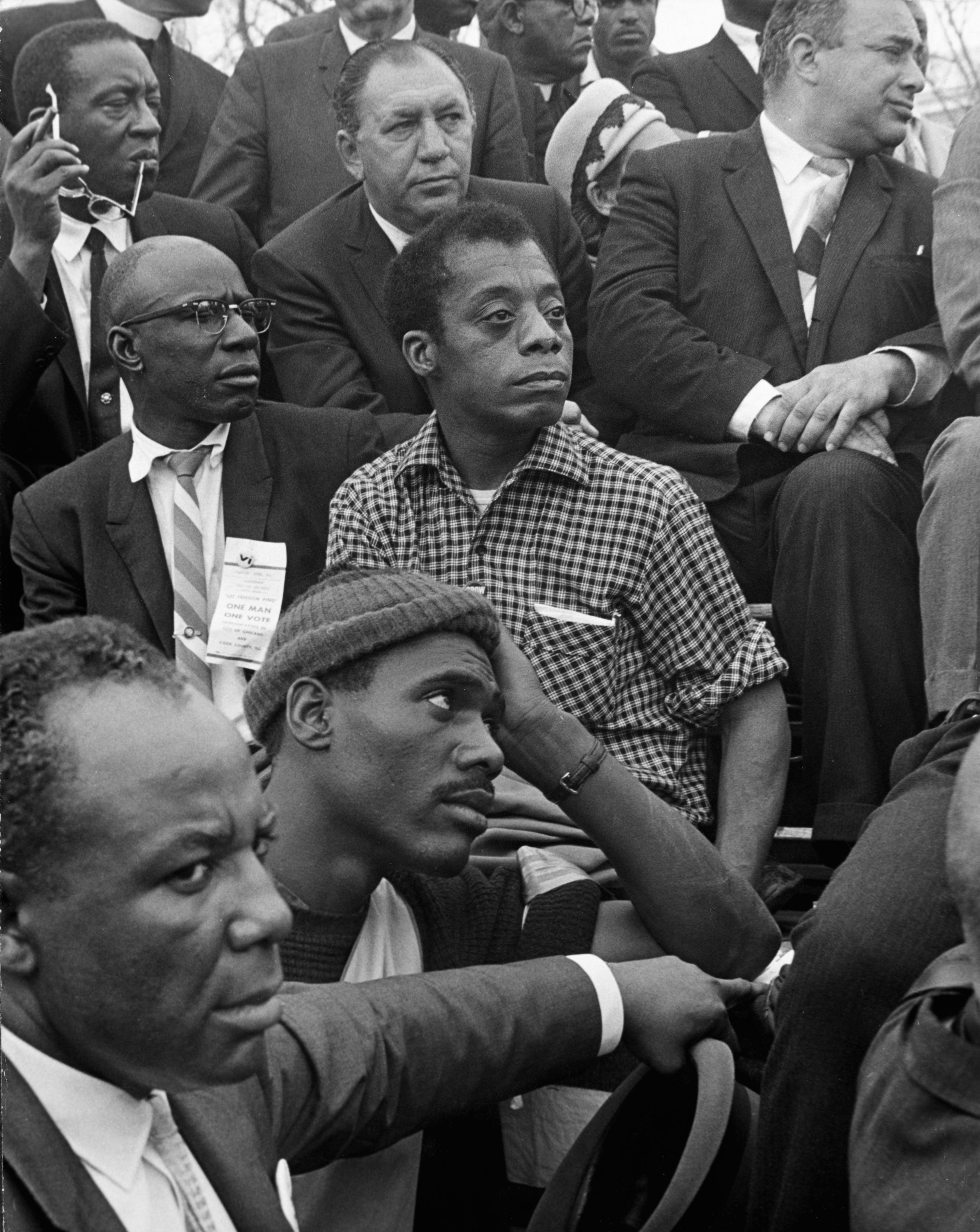 James Baldwin listens to Dr. Martin Luther King, Jr. at the culmination of the Selma to Montgomery March, March 1965. 