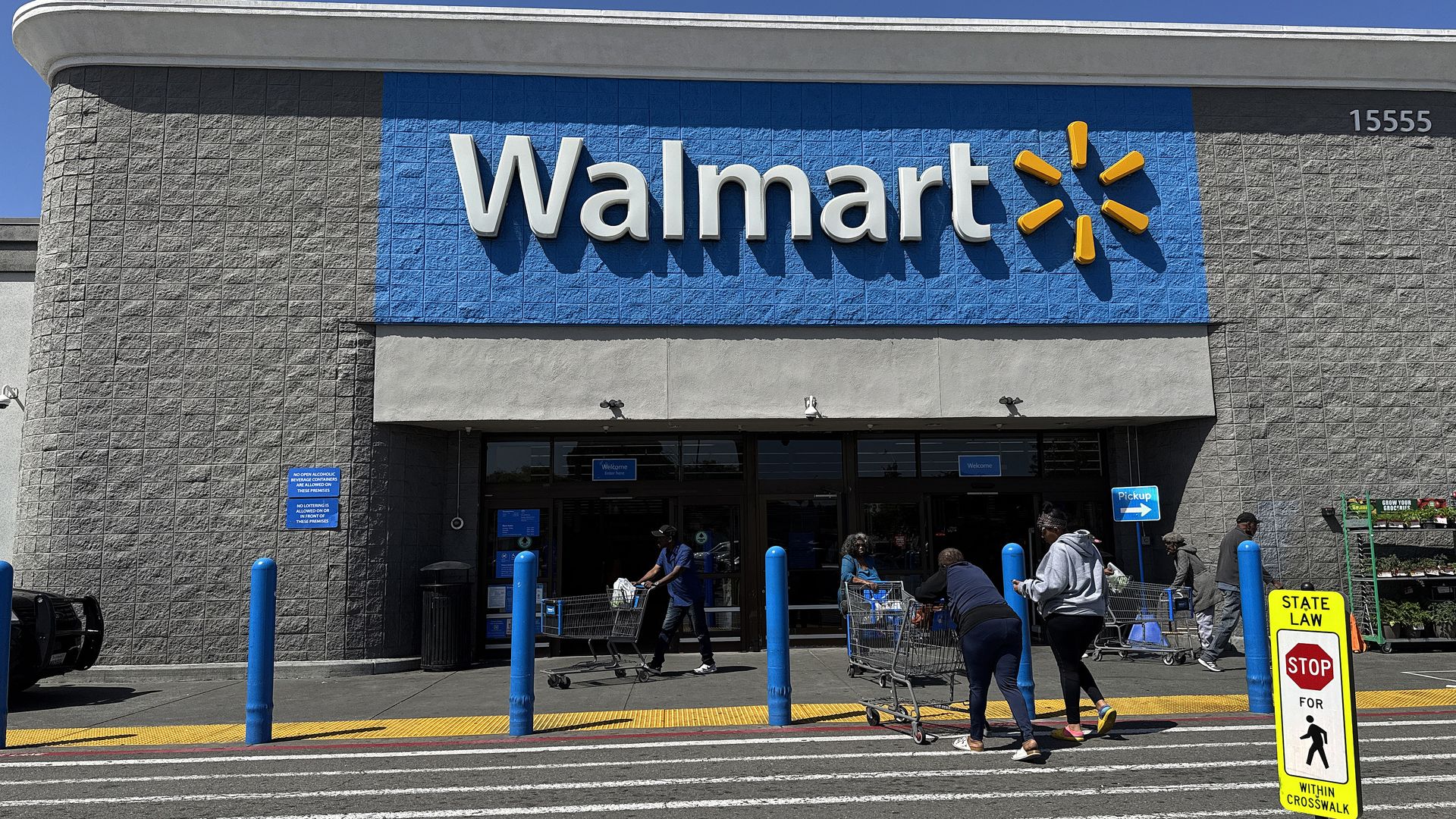 Customers enter a Walmart store on April 09, 2025 in San Leandro, California.