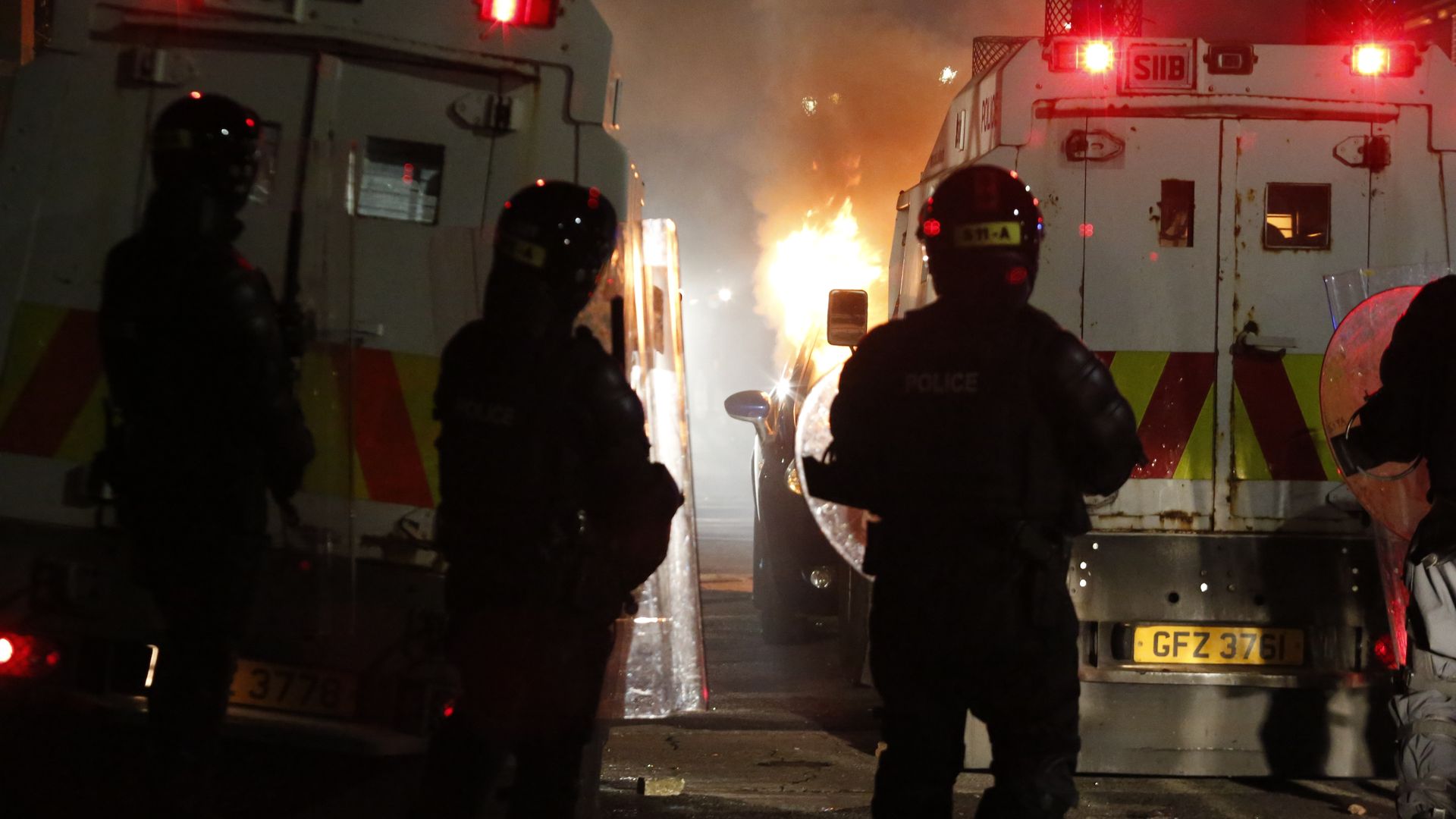 Police before a burning vehicle in Belfast, Northern Ireland, on April 9.