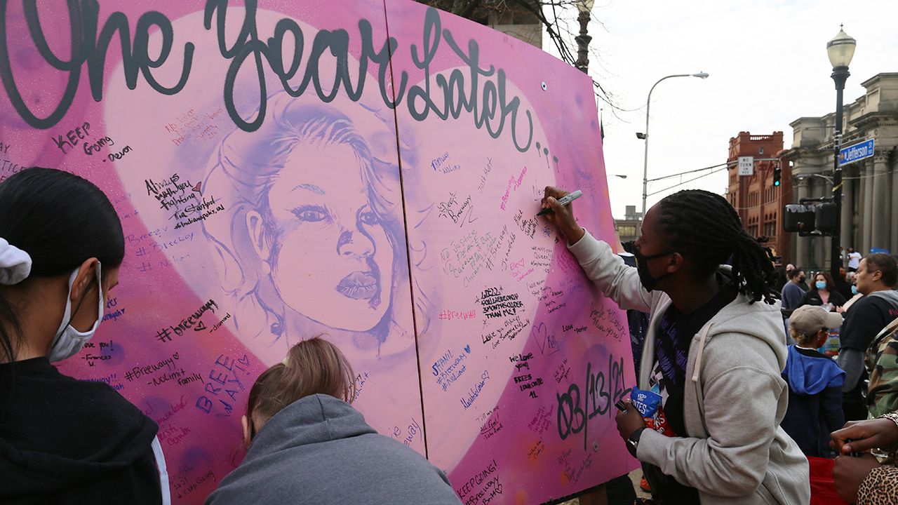 Protesters sign a banner to honor Breonna Taylor's memory. Photo: Laurin-Whitney Gottbrath