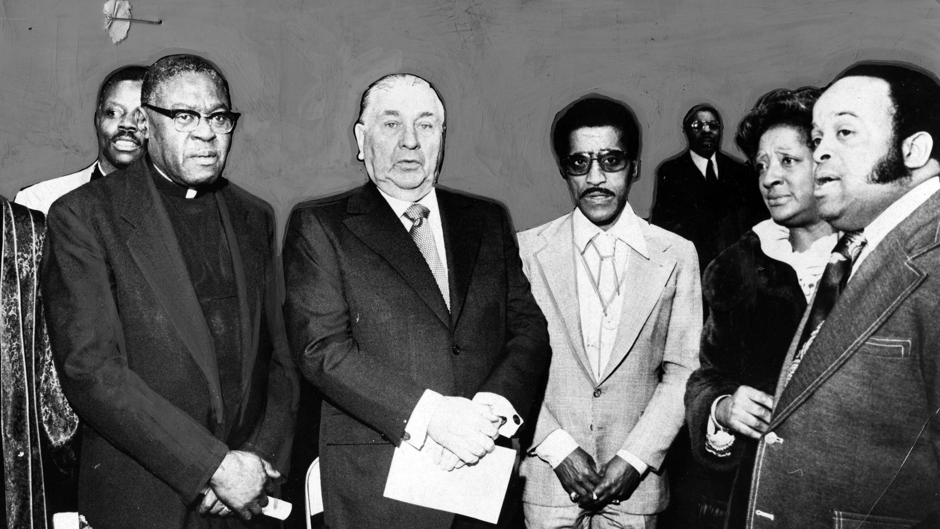 Photo of a bunch of guys standing around in suits. 