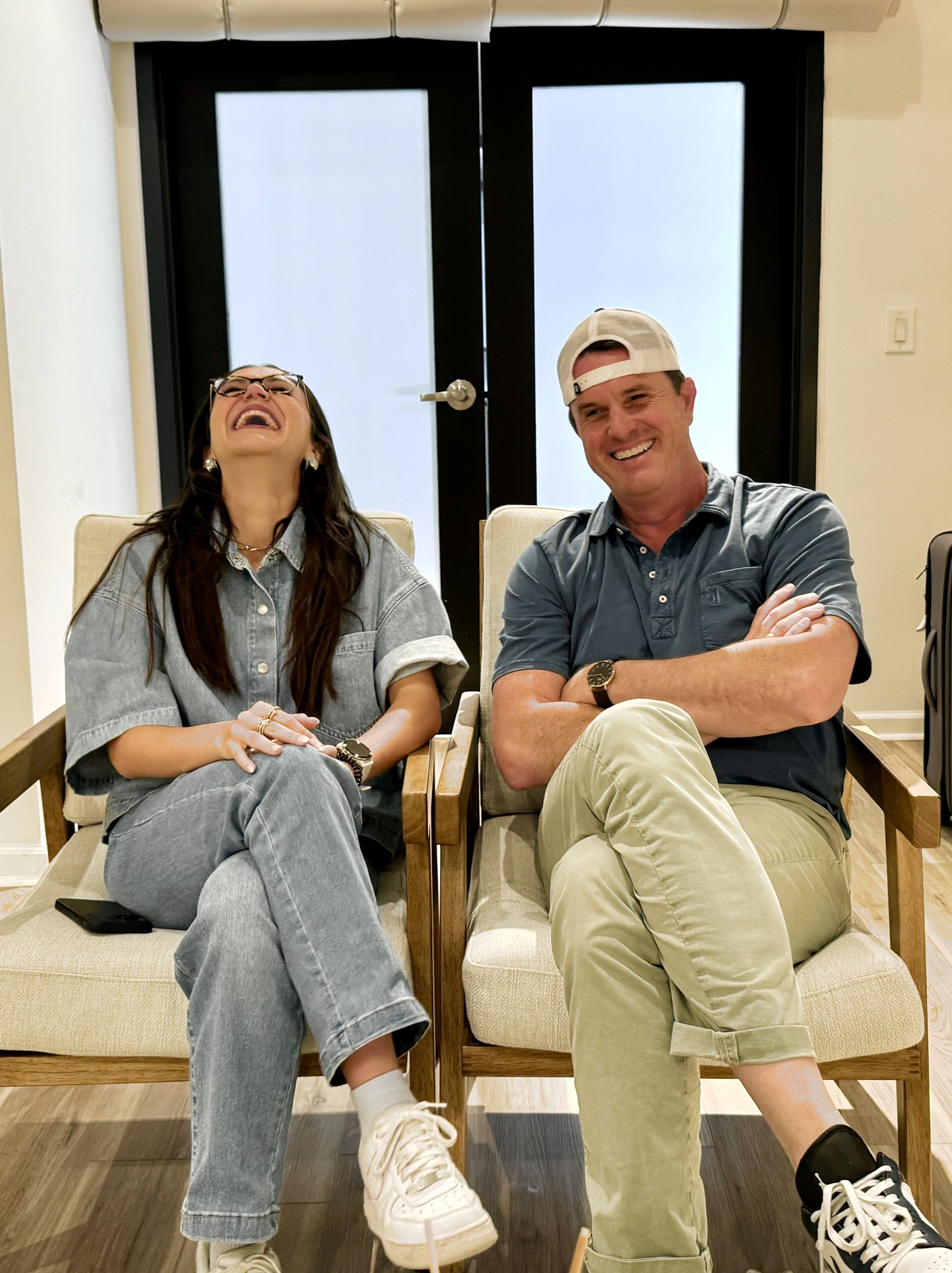 two people sitting next to each other laughing