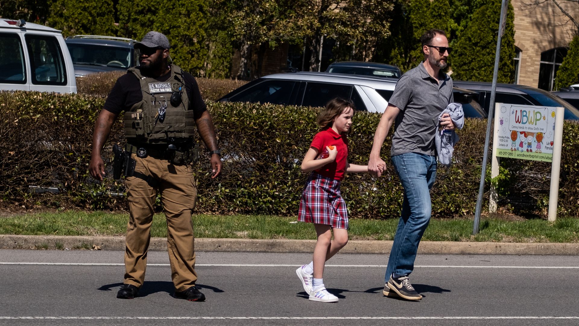 A parent walks with their child from Woodmont Baptist Church where children were reunited with their families after a mass shooting.