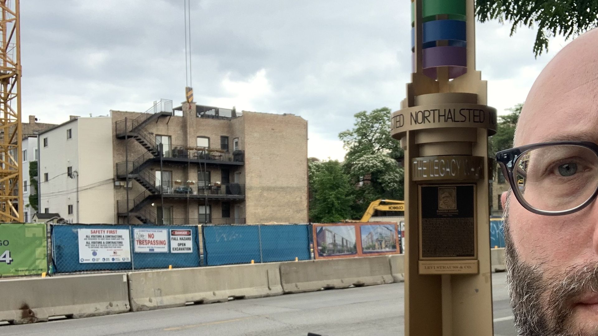 Photo of a man standing in front of a pillar. 