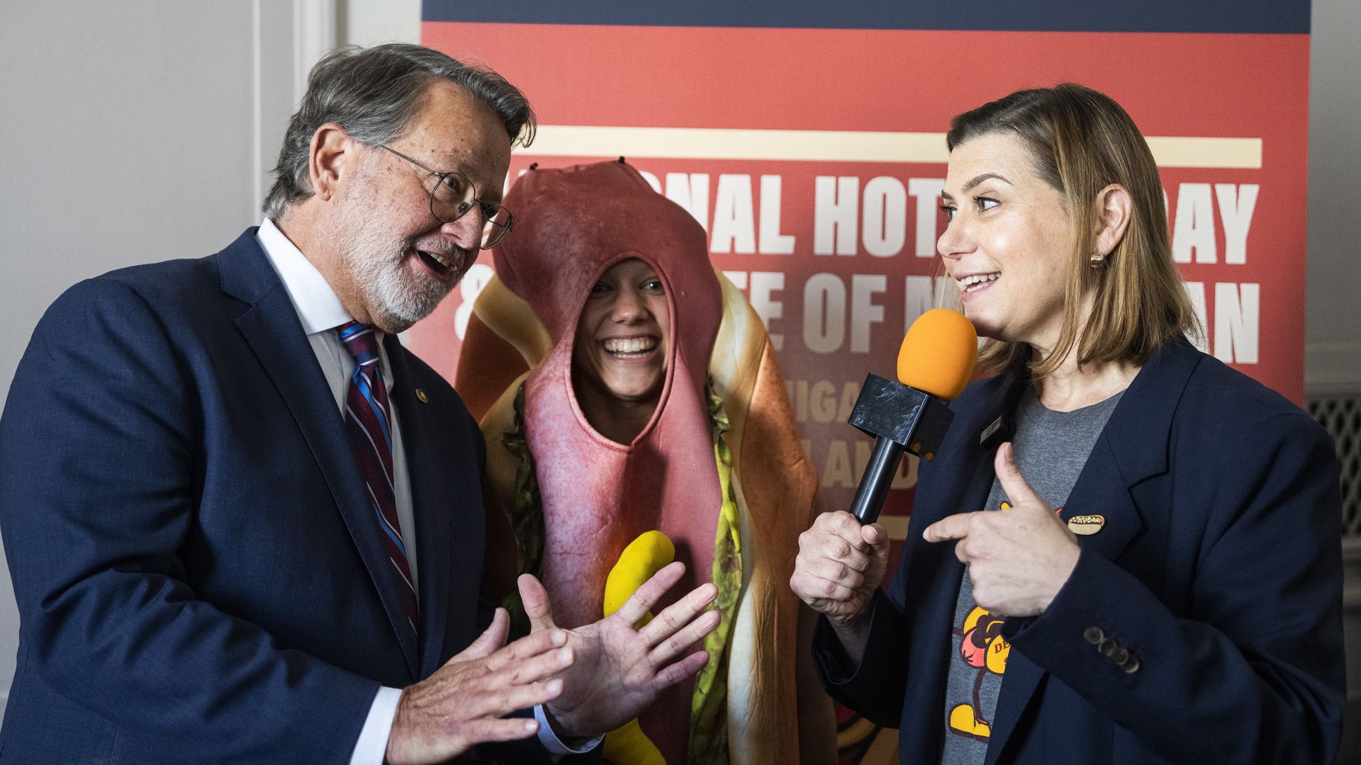 Sen. Elissa Slotkin with Sen. Gary Peters and an aide dressed as a hot dog.