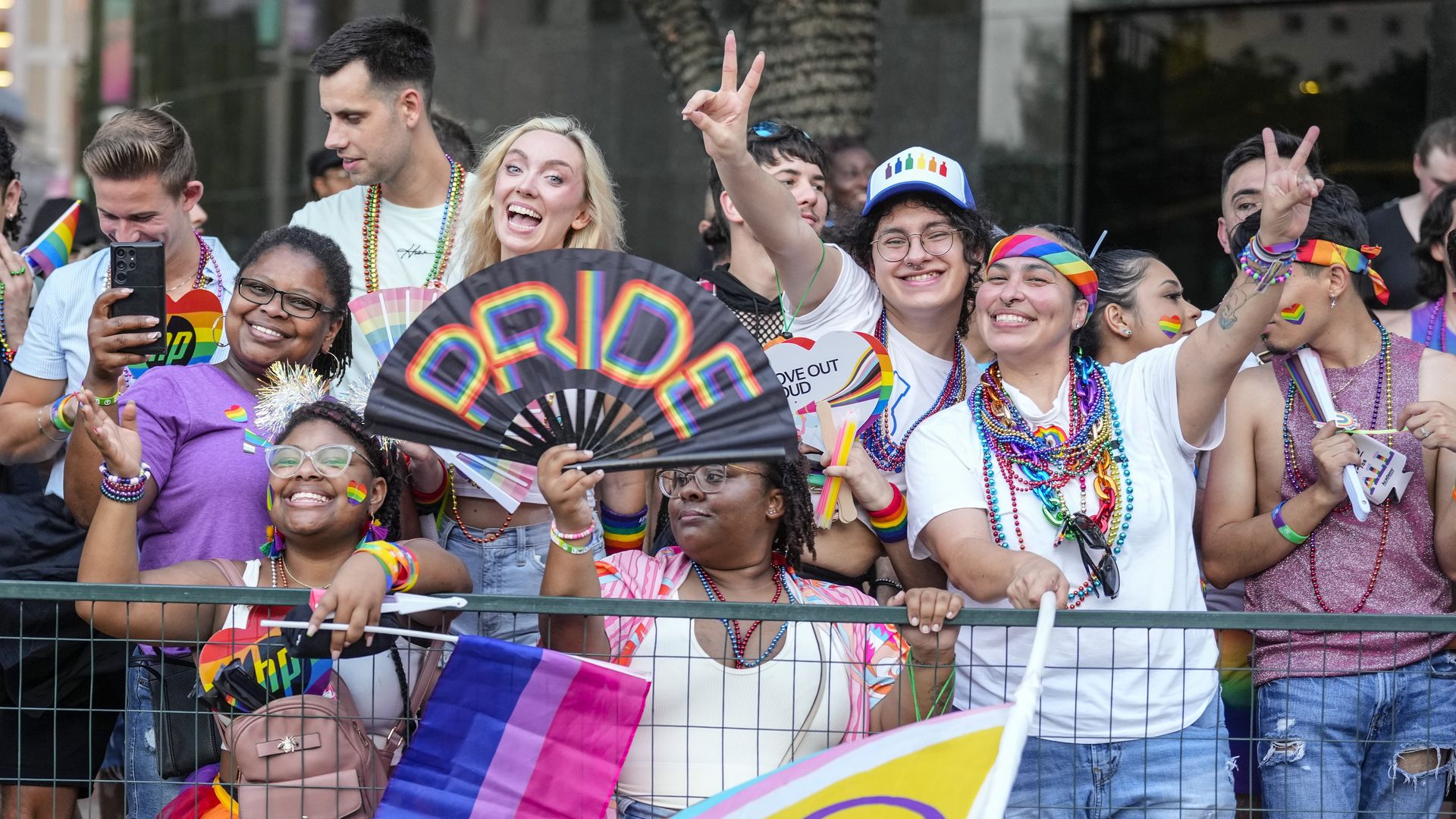 People smile and wave during Houston's Pride parade in 2023