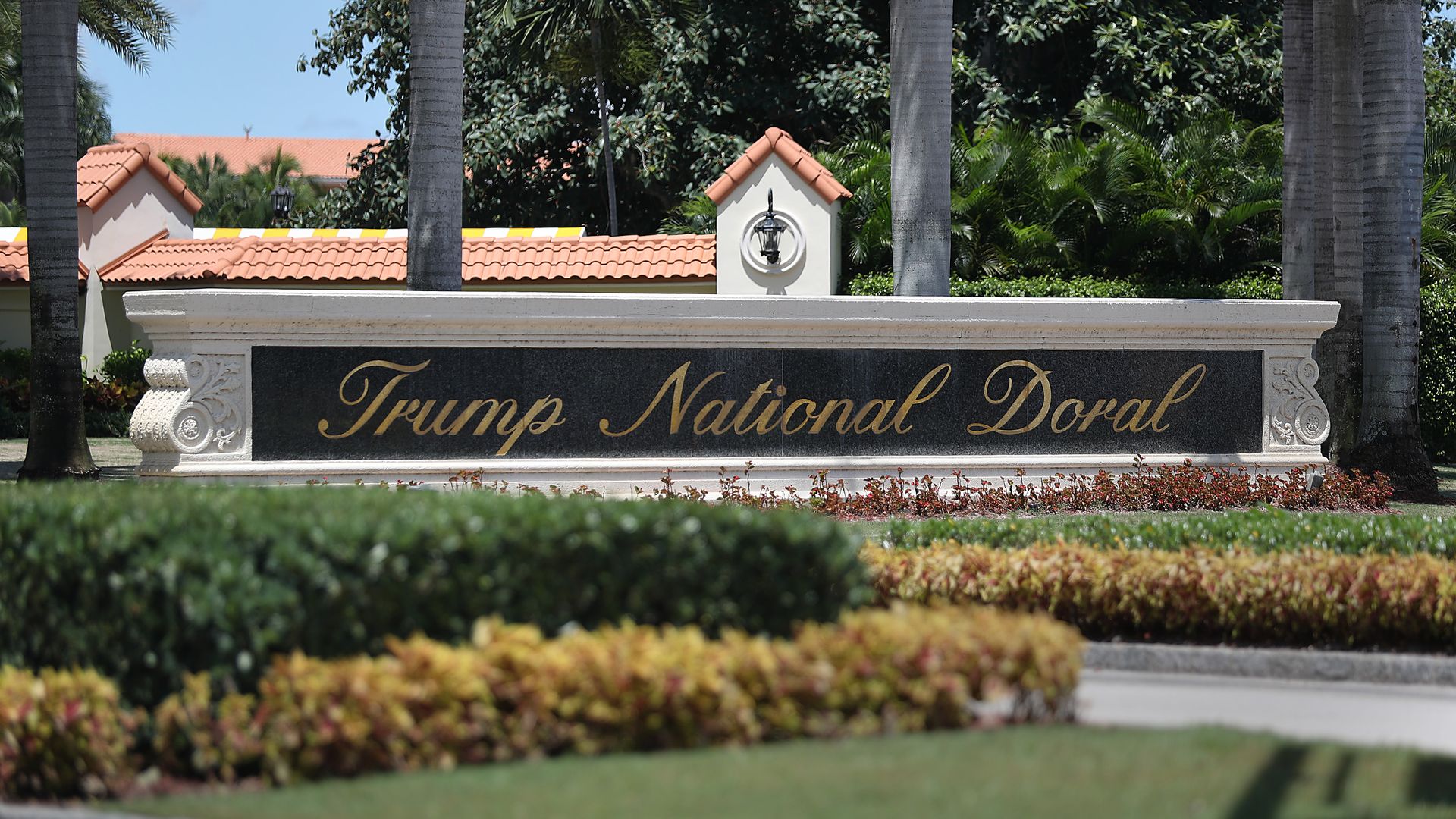 This image shows a large stone sign that says Trump National Doral in a flowing, script font