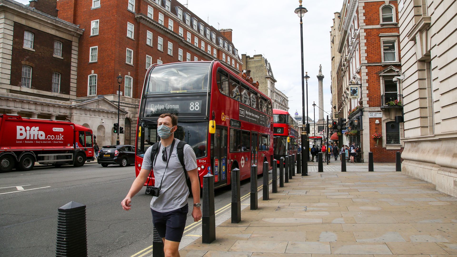  A man wearing a face mask walks on an empty Whitehall on Bank Holiday