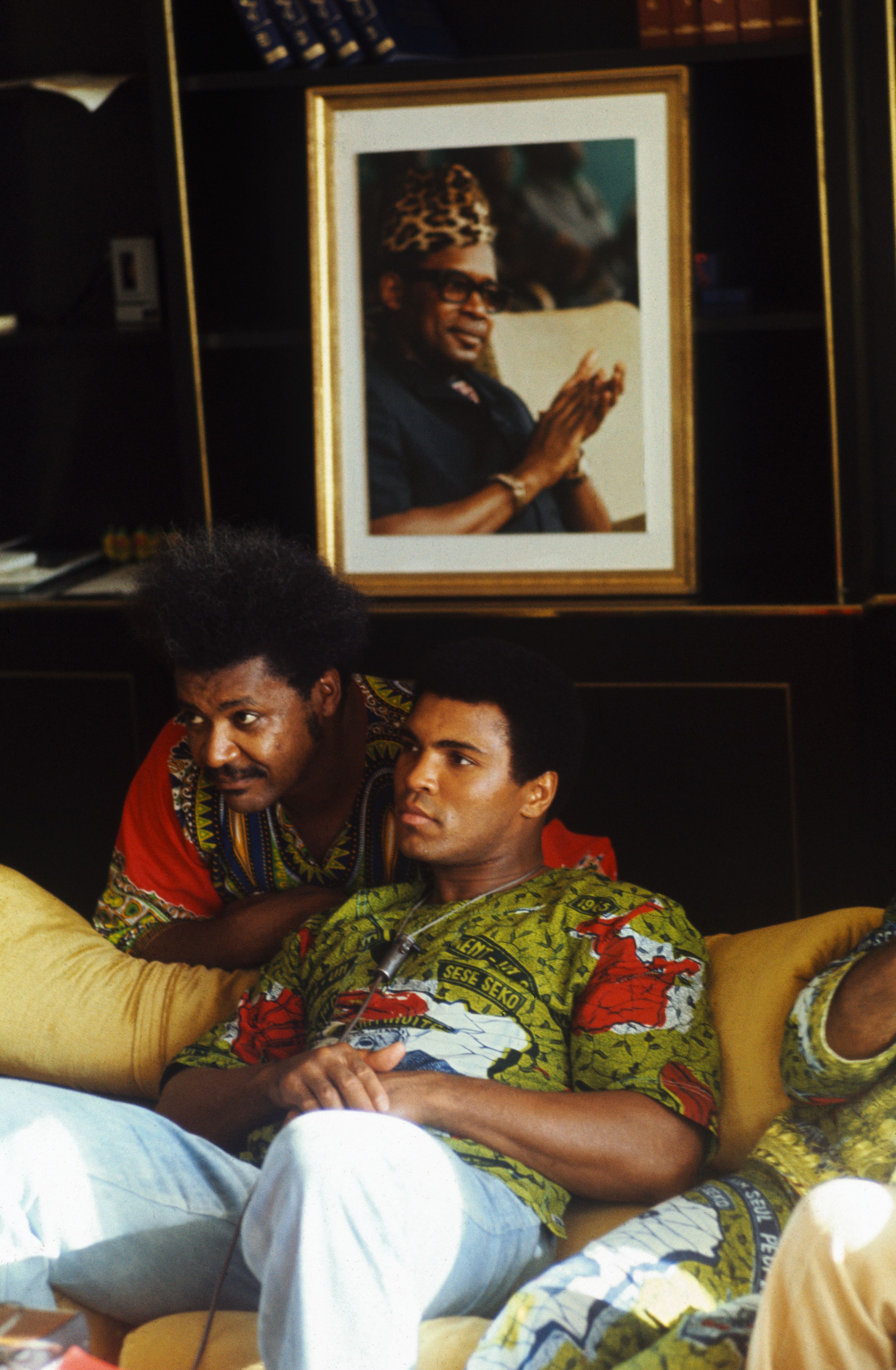 Muhammad Ali and fight promoter Don King in Ali's villa with a portrait of Zaire president Mobutu Sese Seko on the wall behind them.